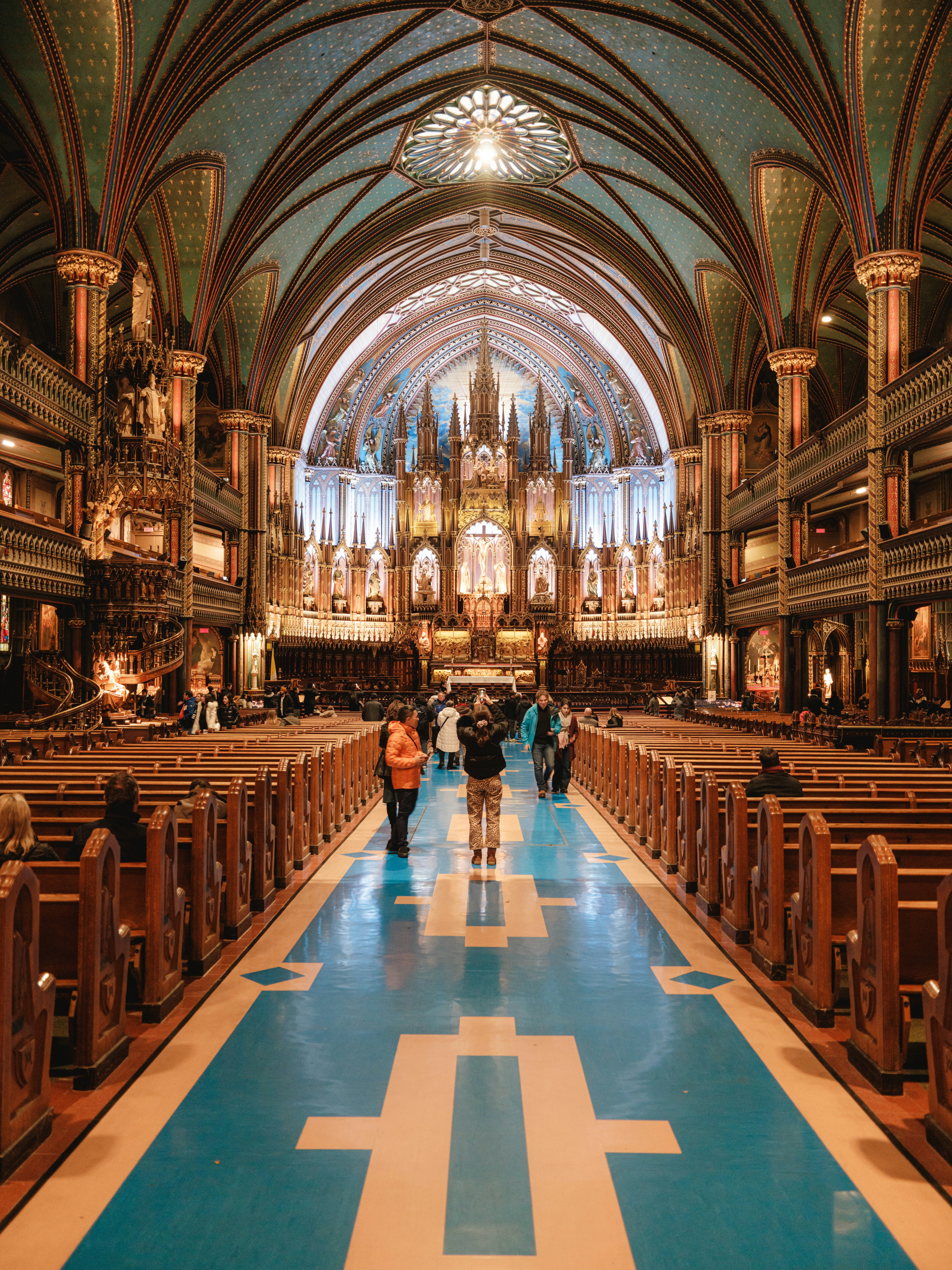 View of a church with stained glass and people taking photographs in it