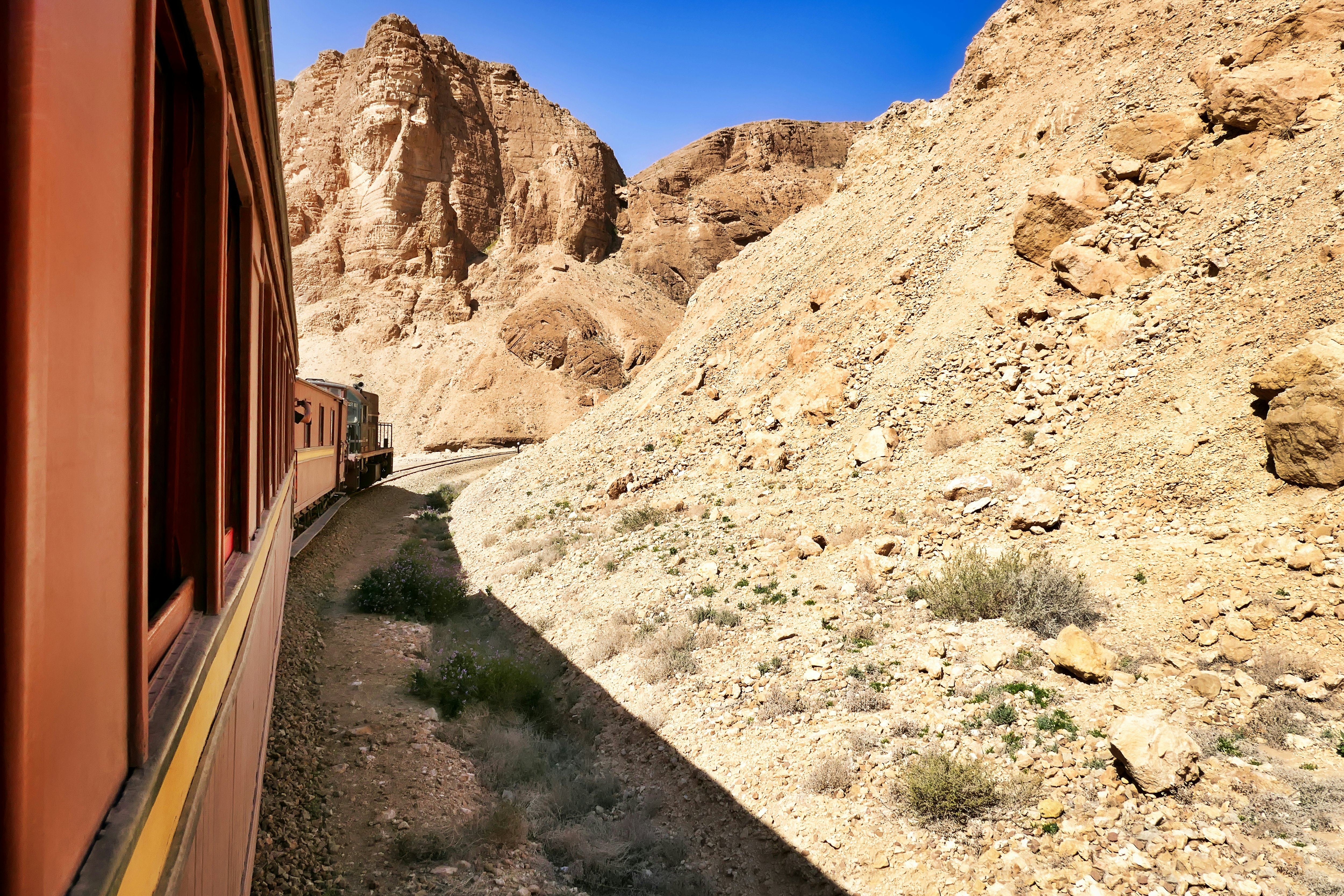 The Lezard Rouge train runs through a rocky gorge between Redeyef and Metlaoui in Tunisia.