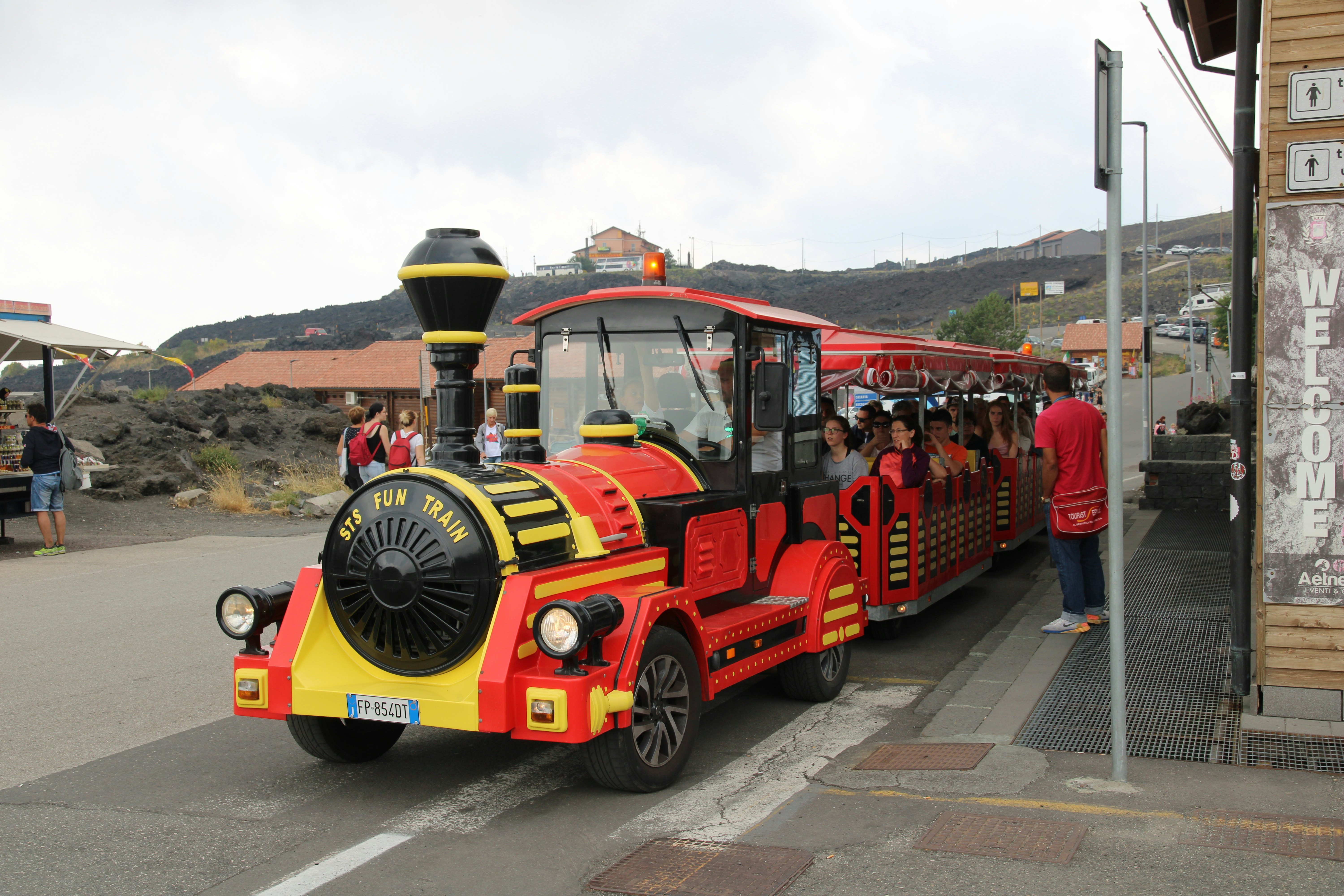 A red and white train collects families and children.