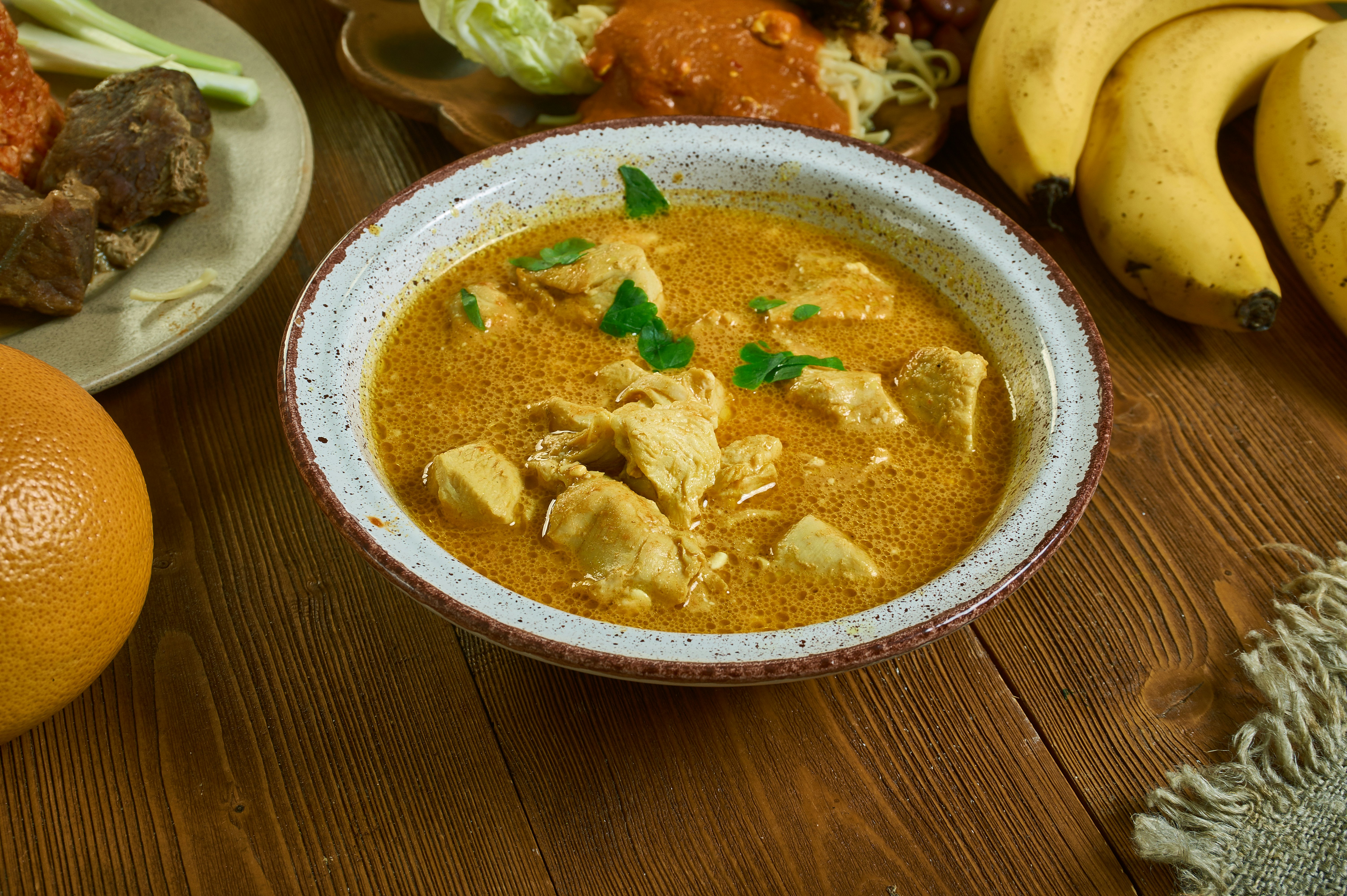 A bowl of traditional groundnut soup in a Ghanaian restaurant.