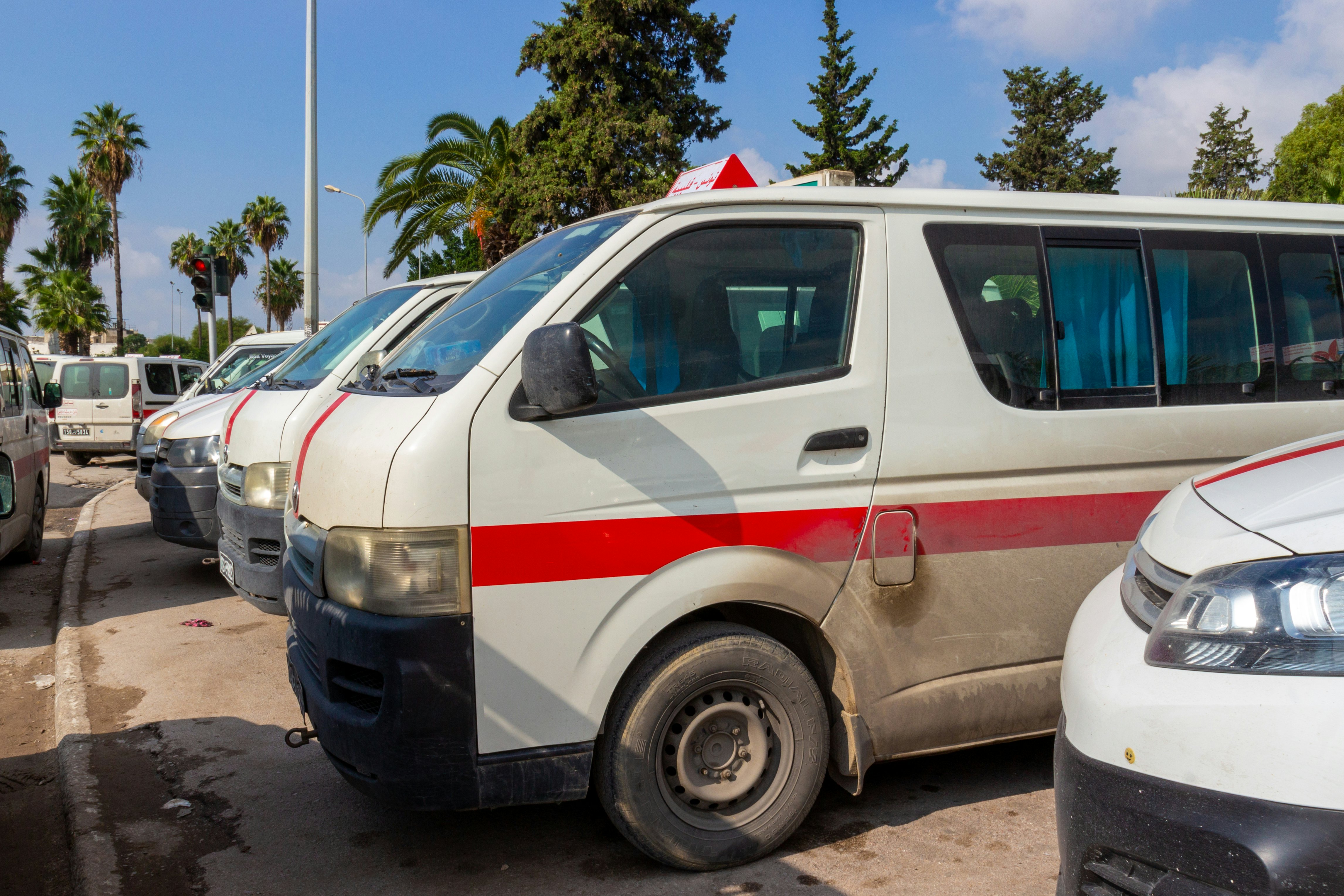 Louages (shared minivans) waiting for passengers in Tunisia.