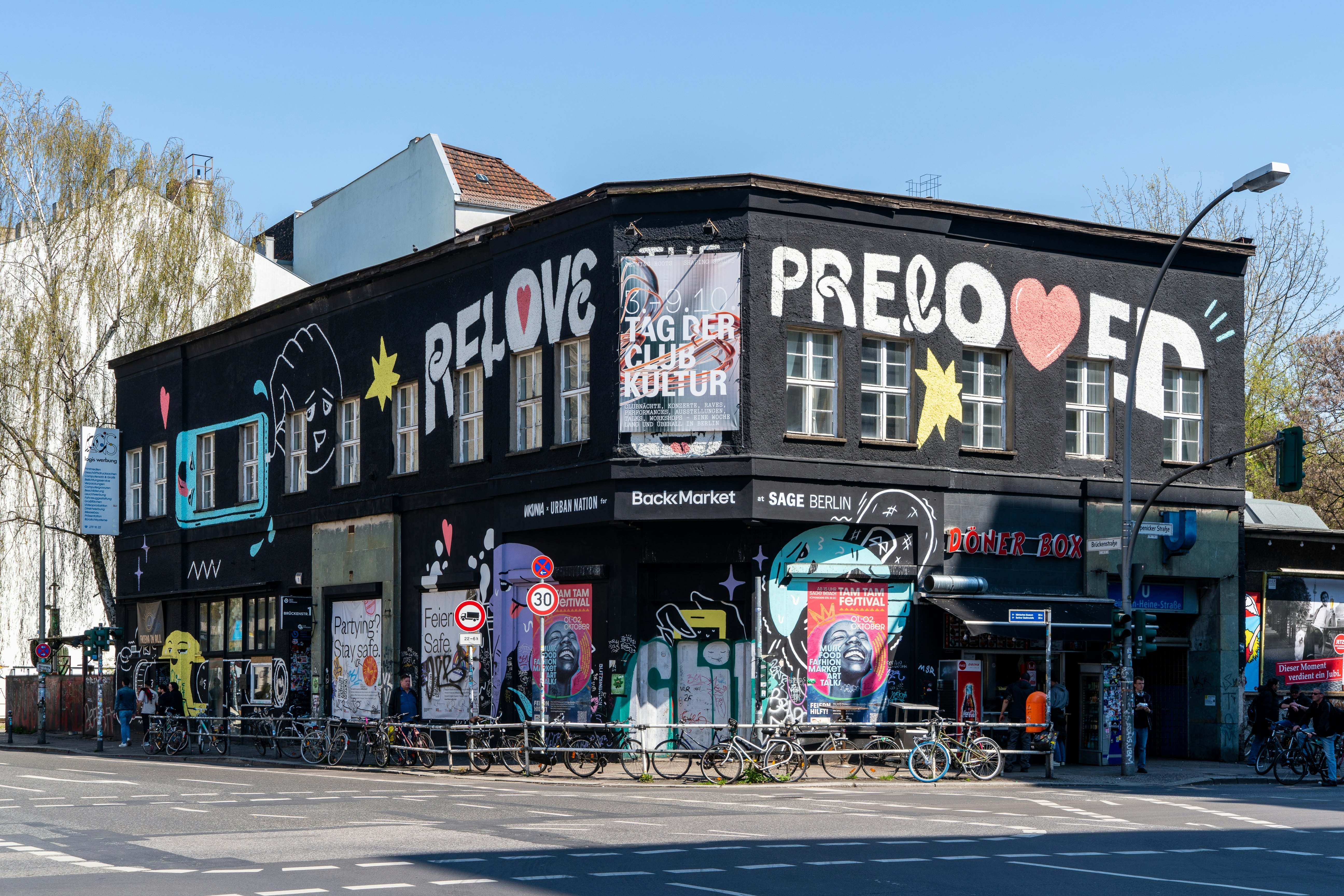 Black painted building on a city street corner on a sunny day.