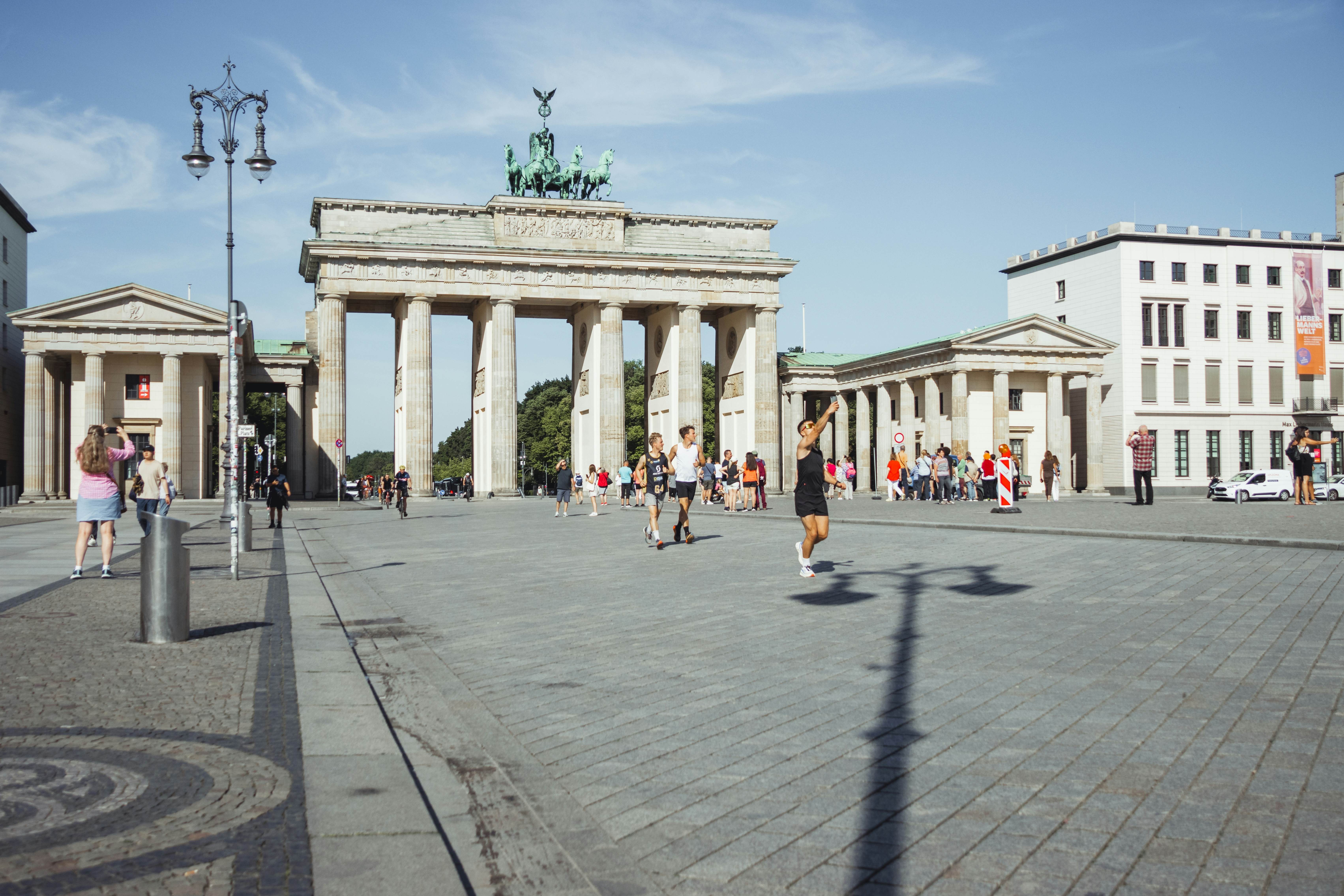 BERLIN, GERMANY - AUGUST 14 2023. Cyclists on Pariser Platz in front of the Brandenburg Gate in central Berlin on a sunny morning., License Type: media, Download Time: 2025-11-11T17:25:10.000Z, User: leahwoodruff76, Editorial: true, purchase_order: 56530 - Guidebooks, job: Photo, client: Pocket Berlin 9, other: Leah Woodruff