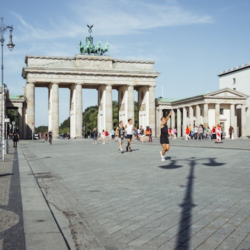 BERLIN, GERMANY - AUGUST 14 2023. Cyclists on Pariser Platz in front of the Brandenburg Gate in central Berlin on a sunny morning., License Type: media, Download Time: 2025-11-11T17:25:10.000Z, User: leahwoodruff76, Editorial: true, purchase_order: 56530 - Guidebooks, job: Photo, client: Pocket Berlin 9, other: Leah Woodruff