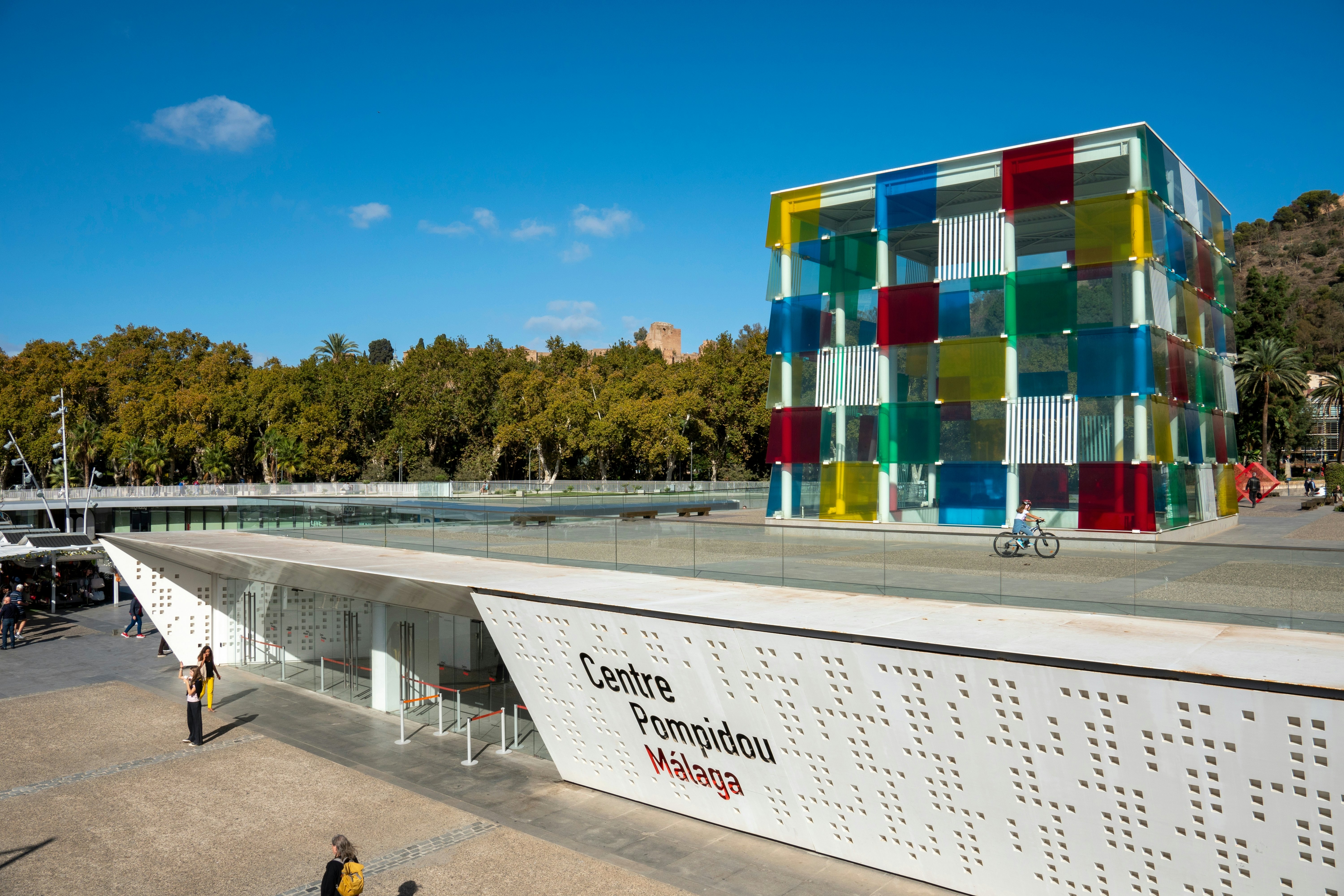 A white low-profile bulding with a colorful cube on its roof.
