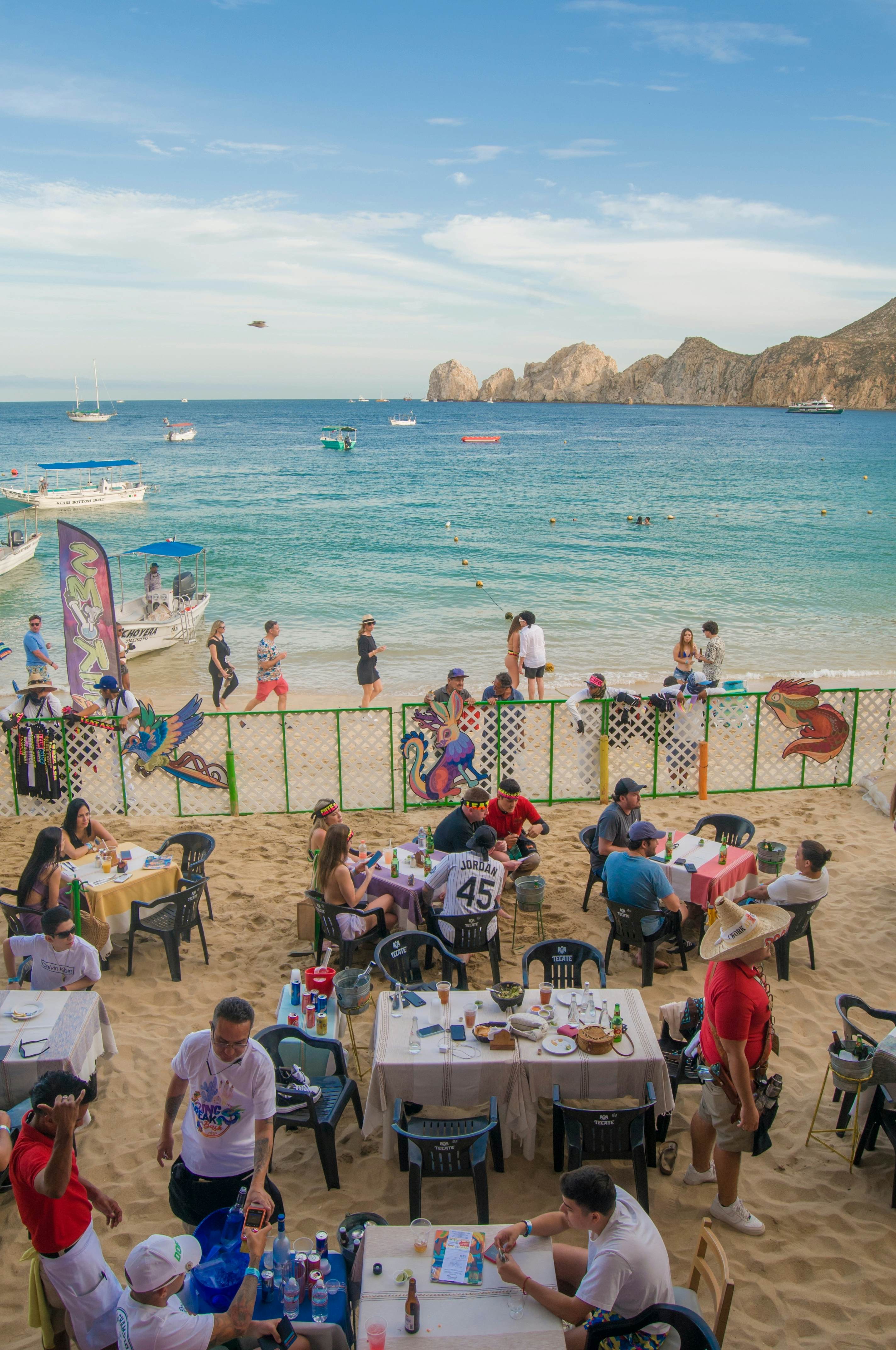 people at a table with a gate and ocean in the background 
