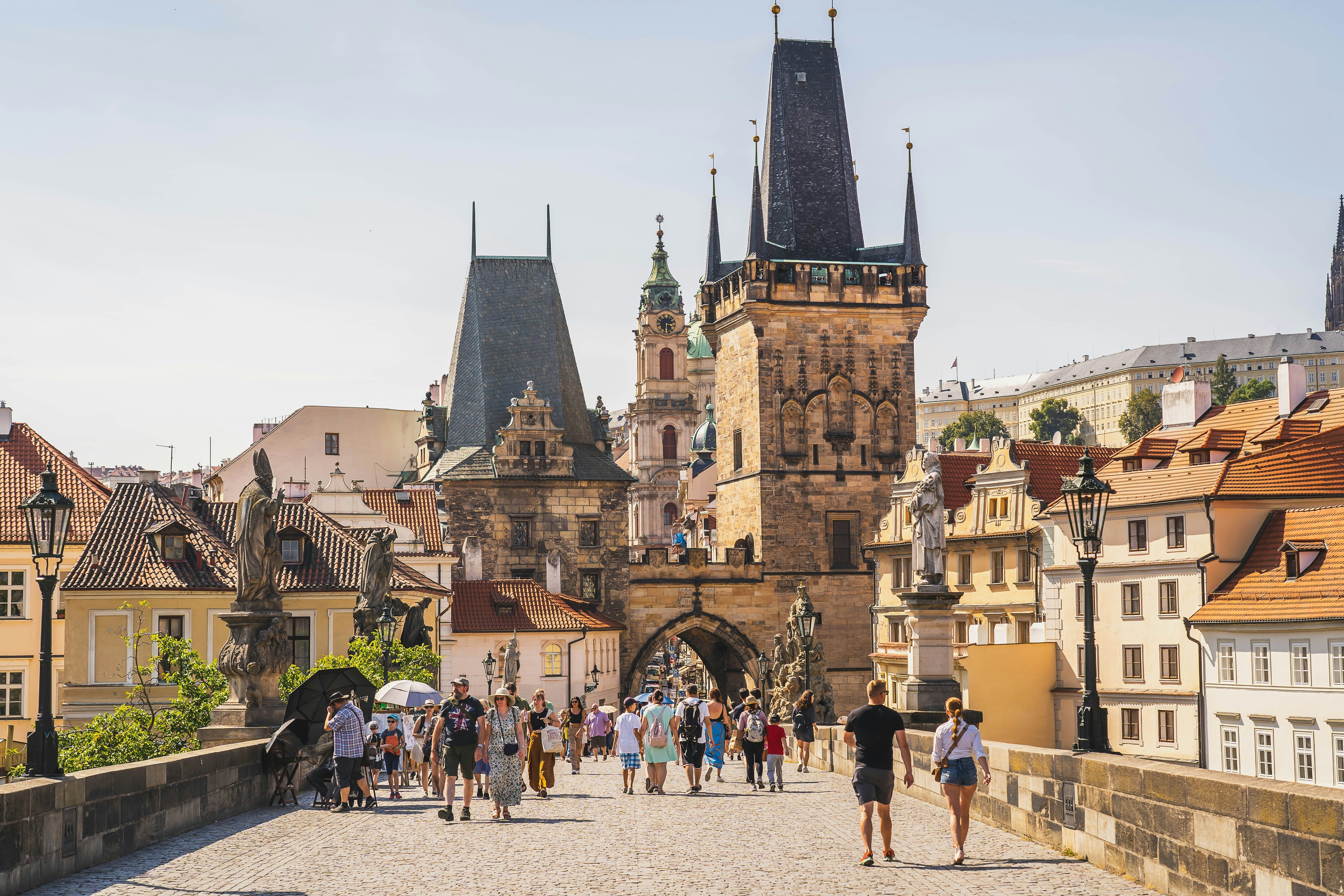 Sightseers on the Charles Bridge in Prague, Czechia, looking towards the spires of the old city.