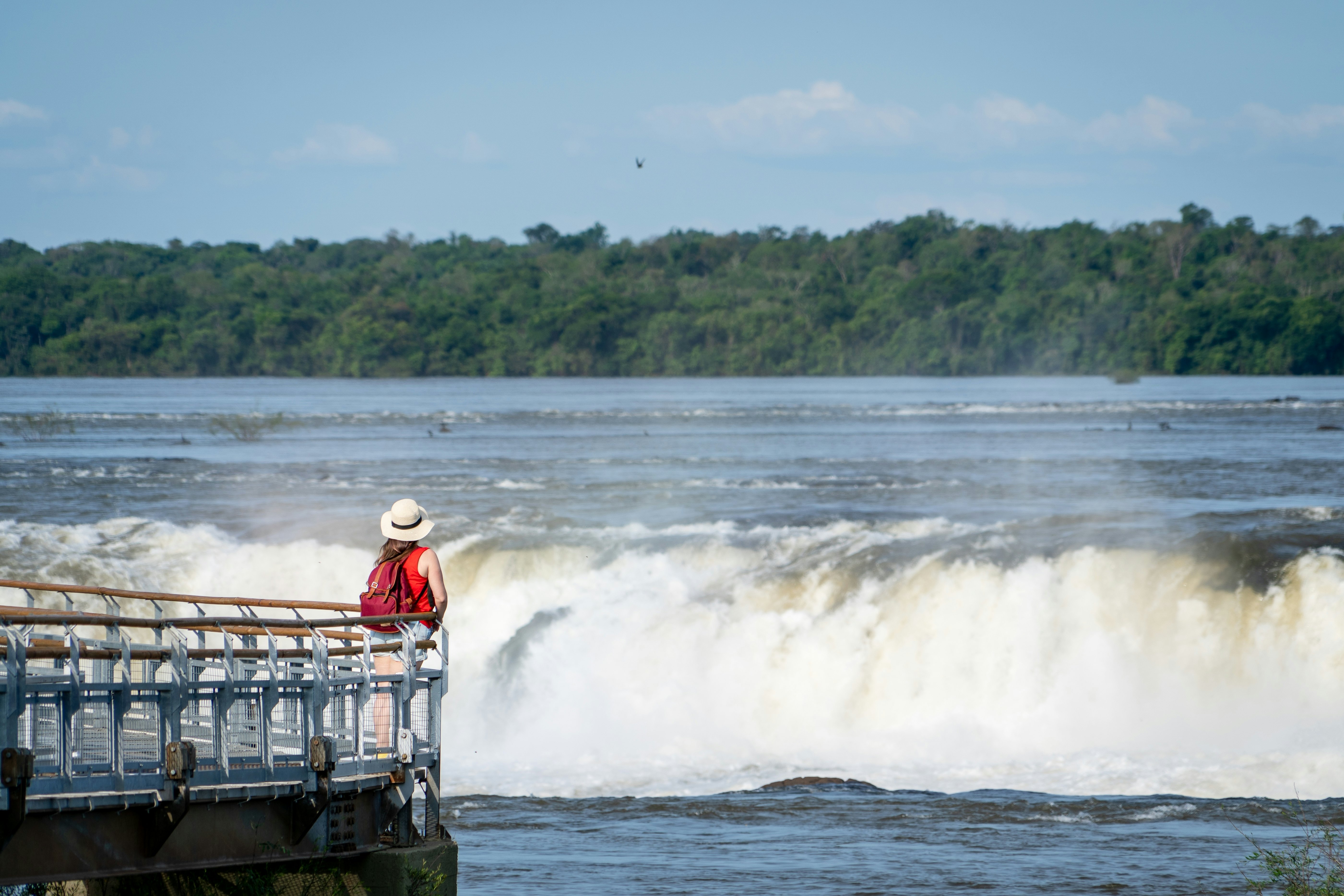 Young tourist admiring the imposing Devil's Throat in Iguazú Falls.
