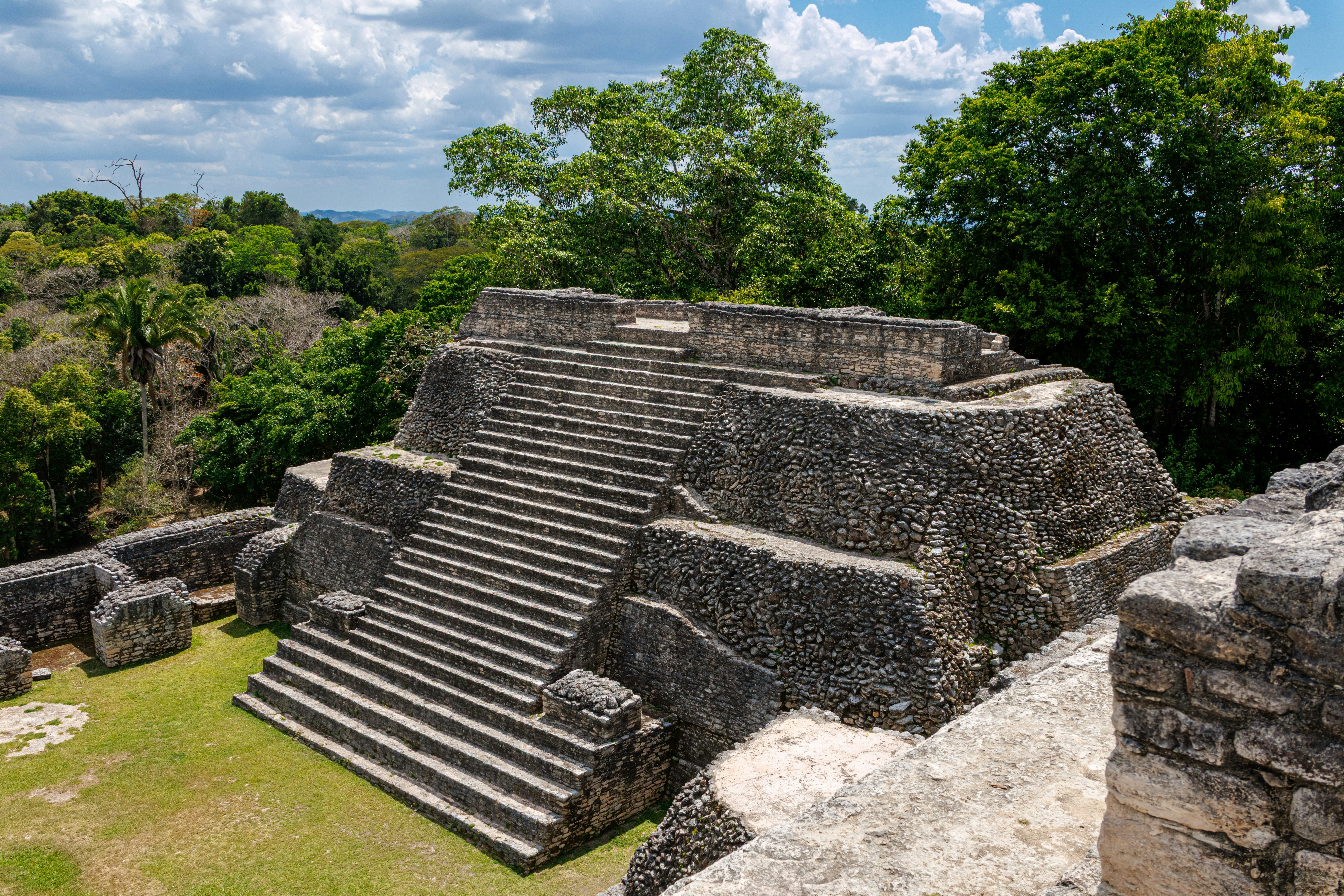 An aerial view of a monumental pyramid with a huge exterior stairway.