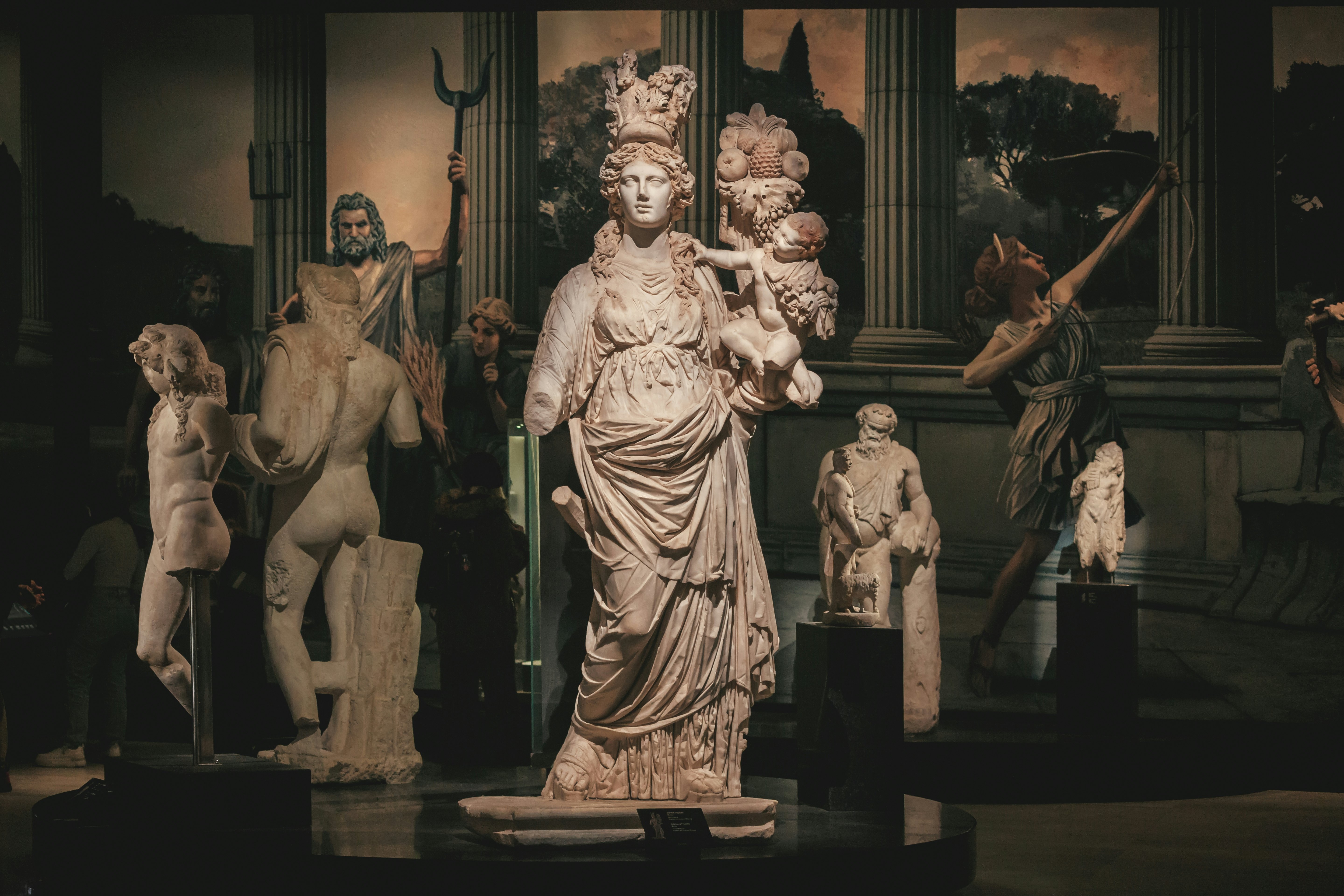 Marble statues on display in a darkened museum.