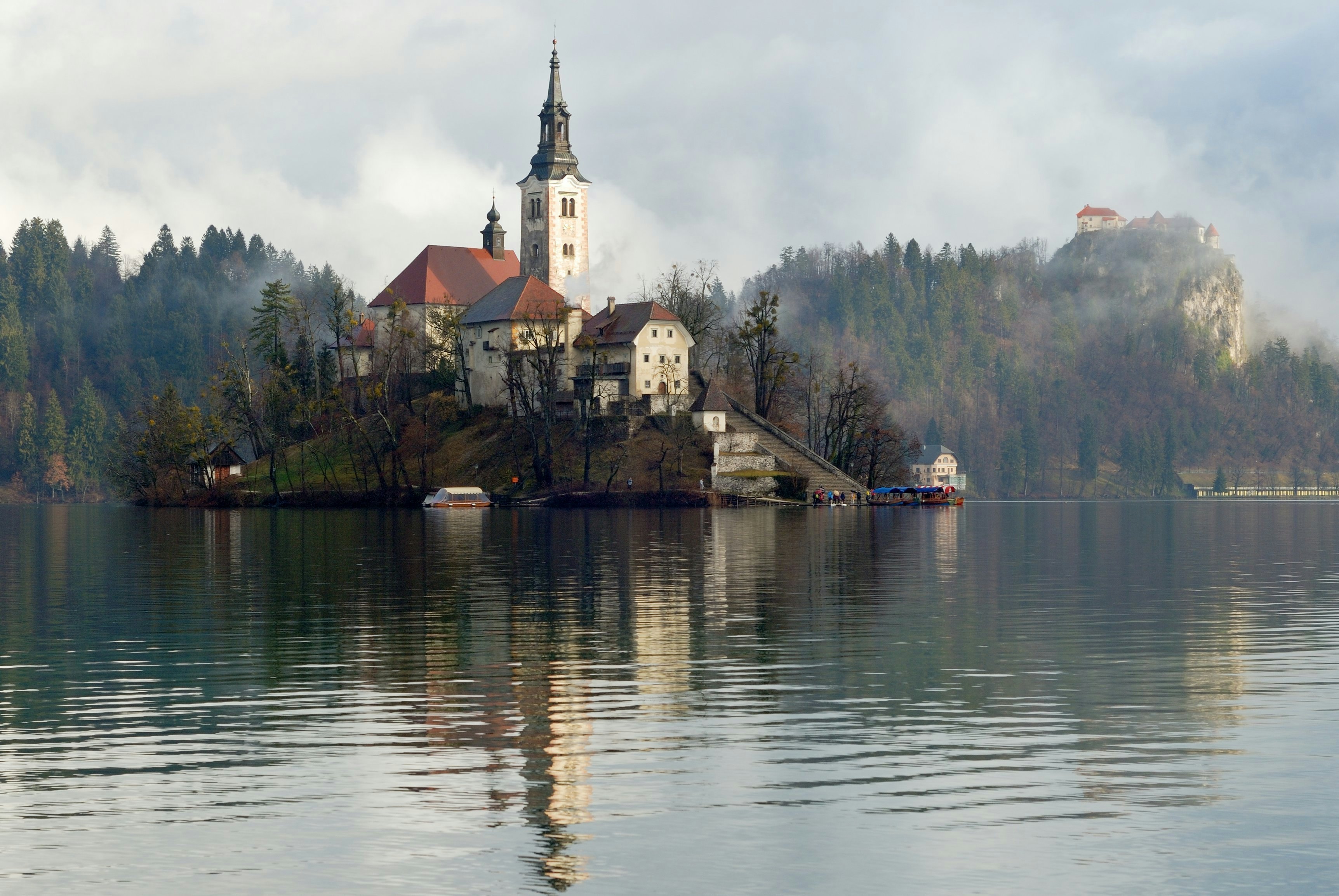 A church located on an island in Lake Bled with the castle in the background, Slovenia