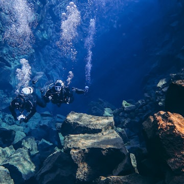 April 5, 2019: Snorkelers and scuba divers swimming in the fissure drift (Silfra Fissure) between tectonic plates with blue crystal clear glacial water.
1366743557
activity, agua, algae, aquatic, beautiful, between tectonic plates, blue, clean, clear, colorful, crack, deep, depth, dive, fissure, formation, glacier cold, green, iceland, lava, marine, mask, national park, natural, nature, ocean, outdoor, people, person, popular, pure, red, reflection, rocks, sand, scuba, sea, snorkel, snorkeler, snorkeling, stones, swim, tourists, transparent, travel, underwater, visibility, volcanic, water, wonder