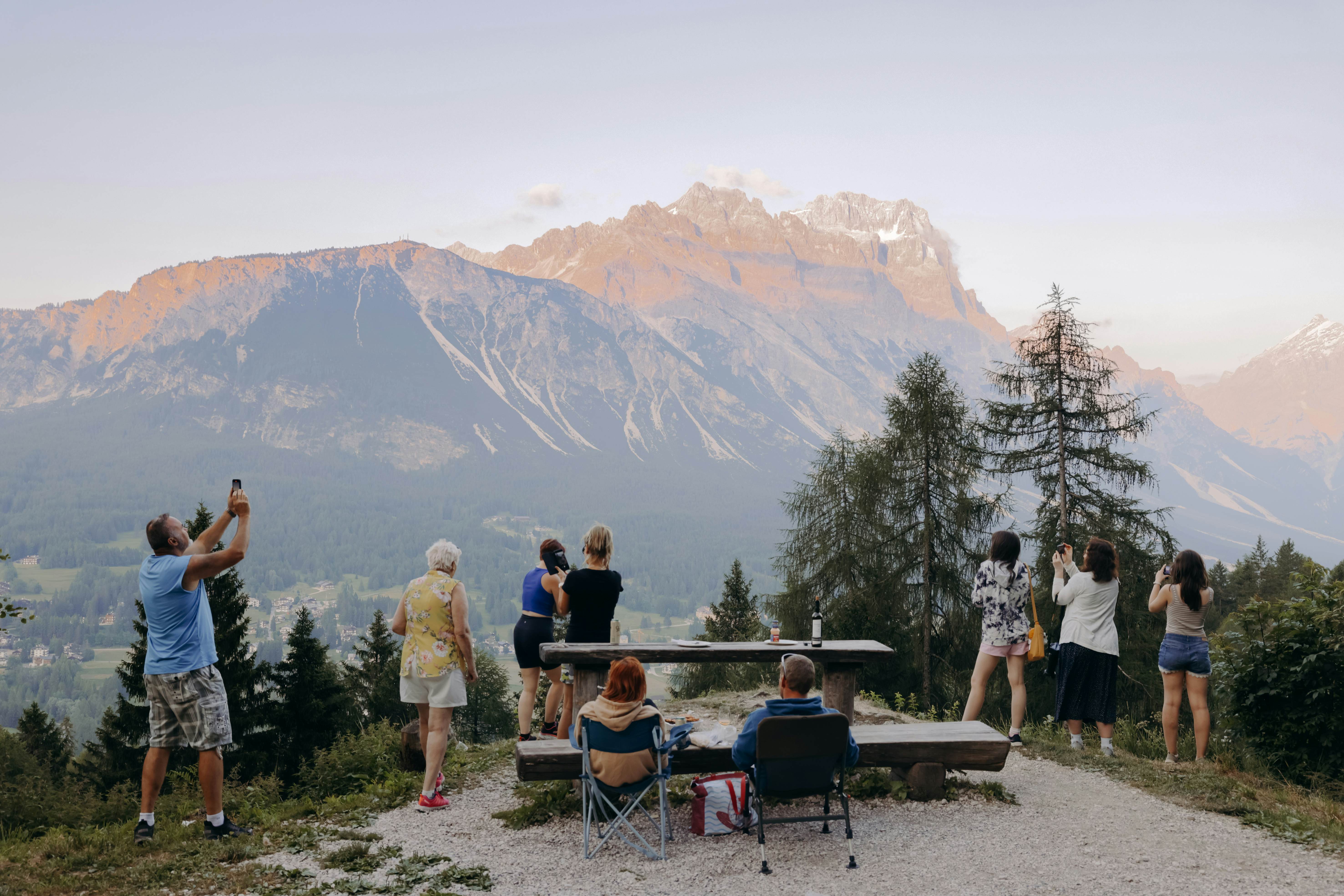 Cortina d'Ampezzo, Italy. June 2025. ..Tourists enjoy the mountain views, some  drink wine and eat grilled meat, with the view of Sorapis and Antelao Mountains. ..Photo by Camilla Ferrari for Lonely Planet