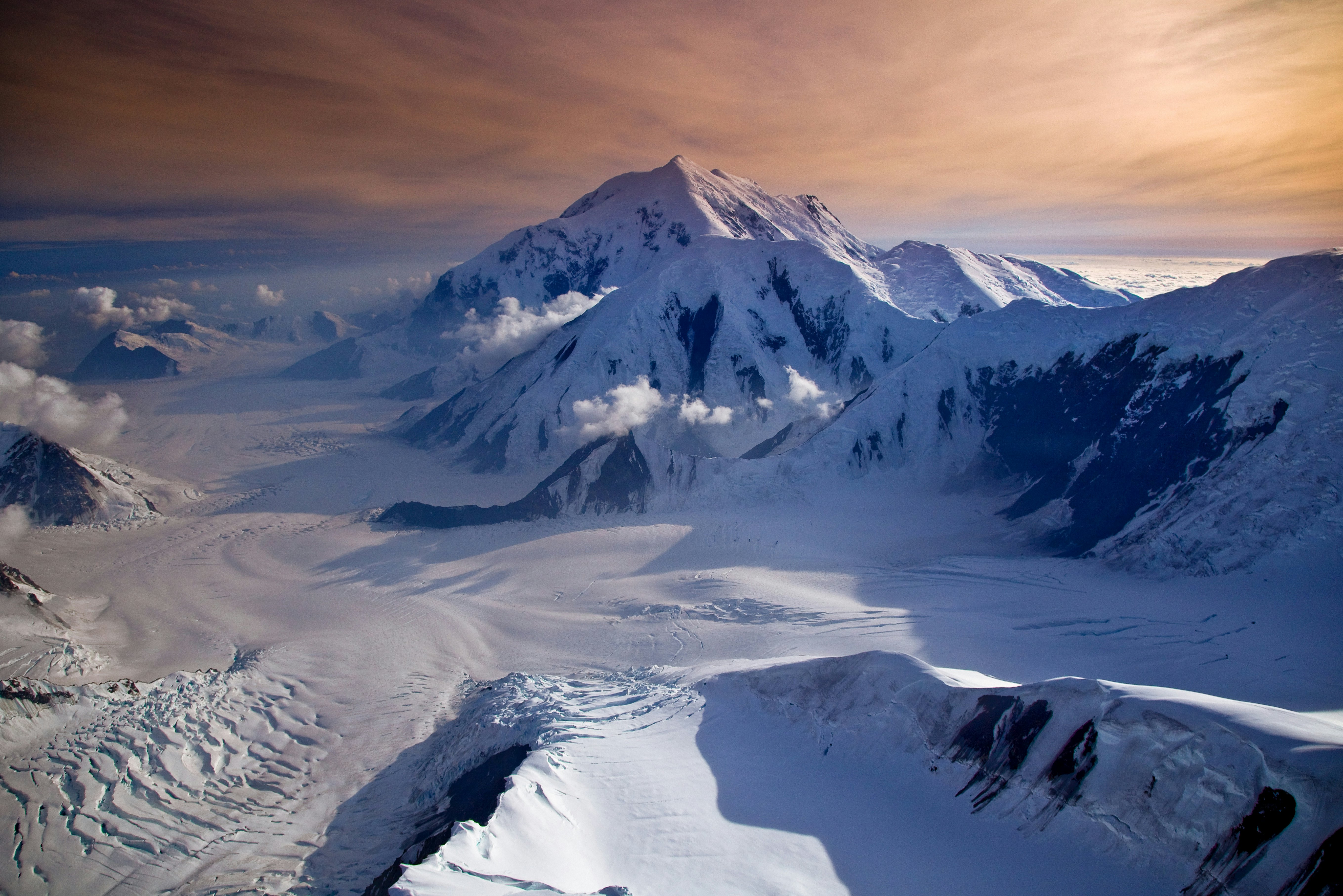 A mountain peak among a range completely covered in snow.