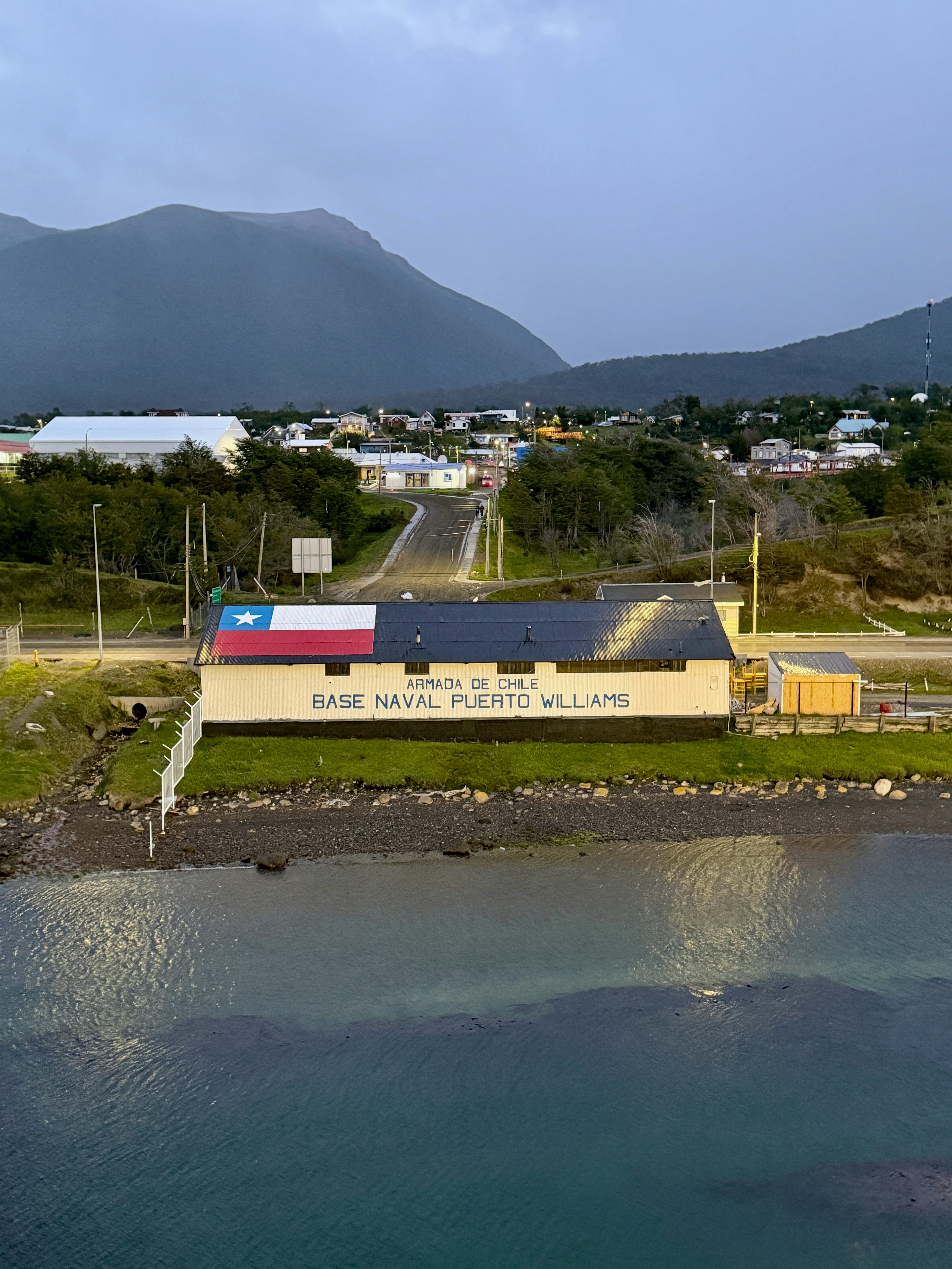 A large building at the edge of the sea with a sign that reads "Armada de Chilem Base Naval Puerto Williams".