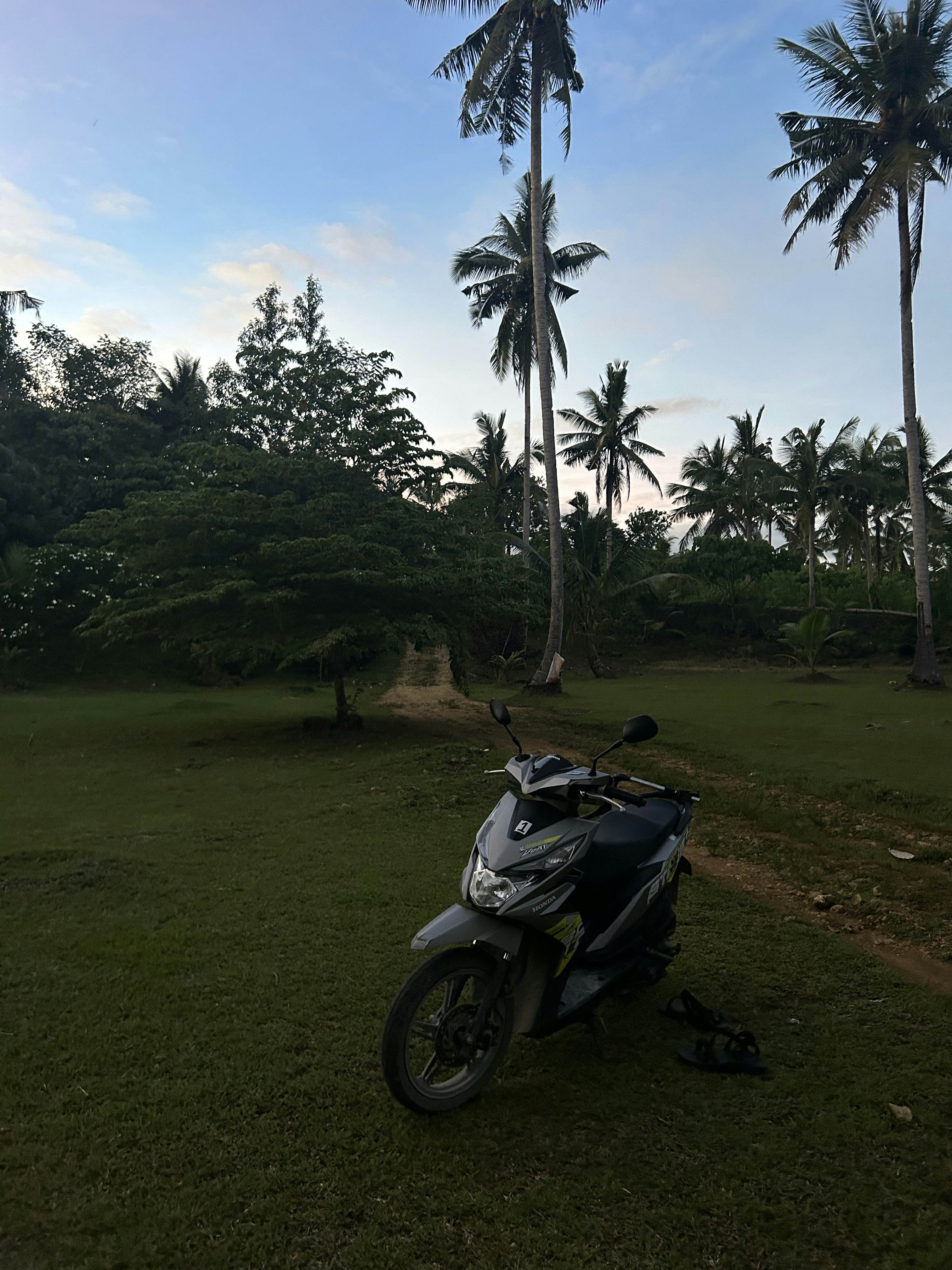 A motorcycle parked on a dirt road. 