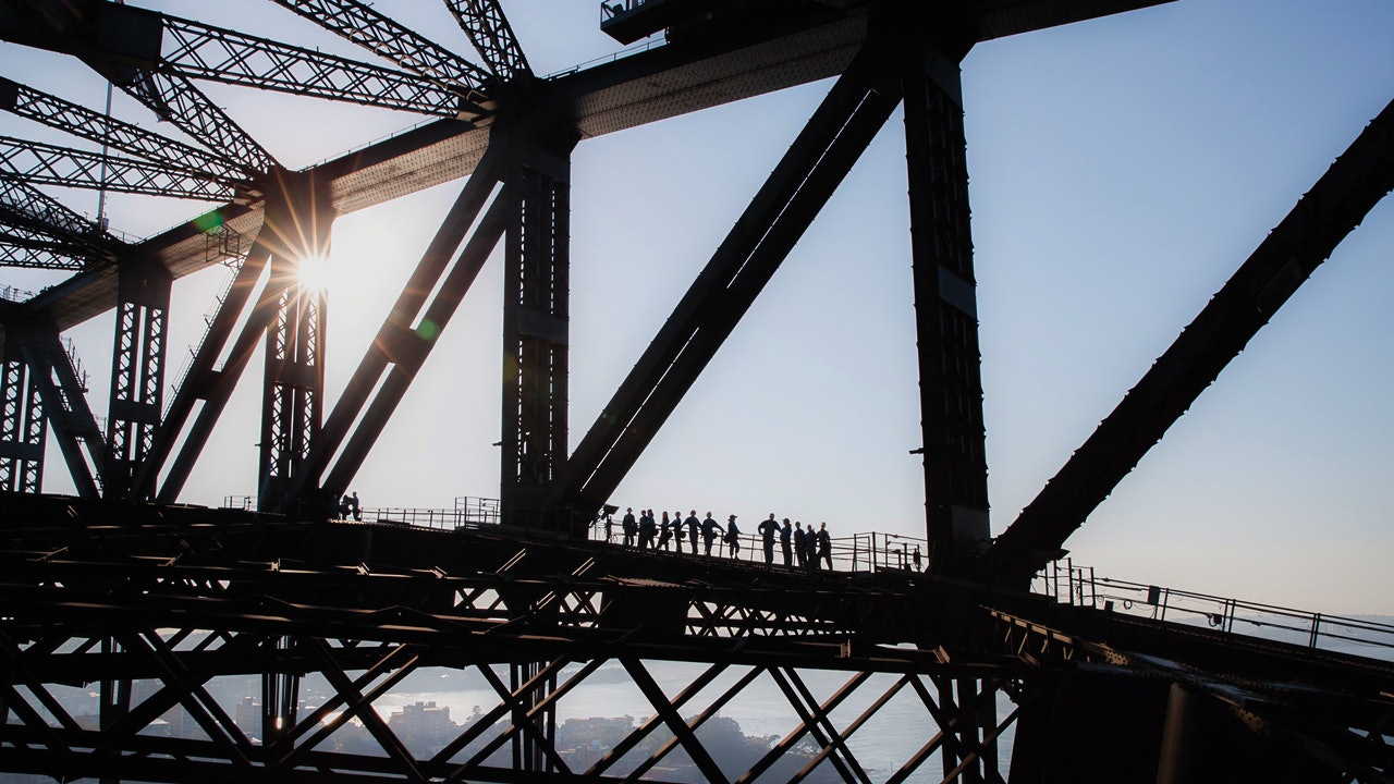 People seen in silhouette during a lower-arch climb of Sydney Harbour Bridge