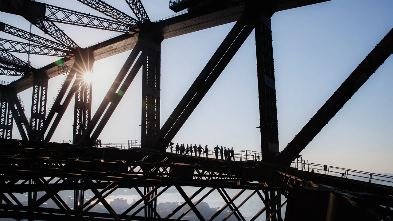 People seen in silhouette during a lower-arch climb of Sydney Harbour Bridge