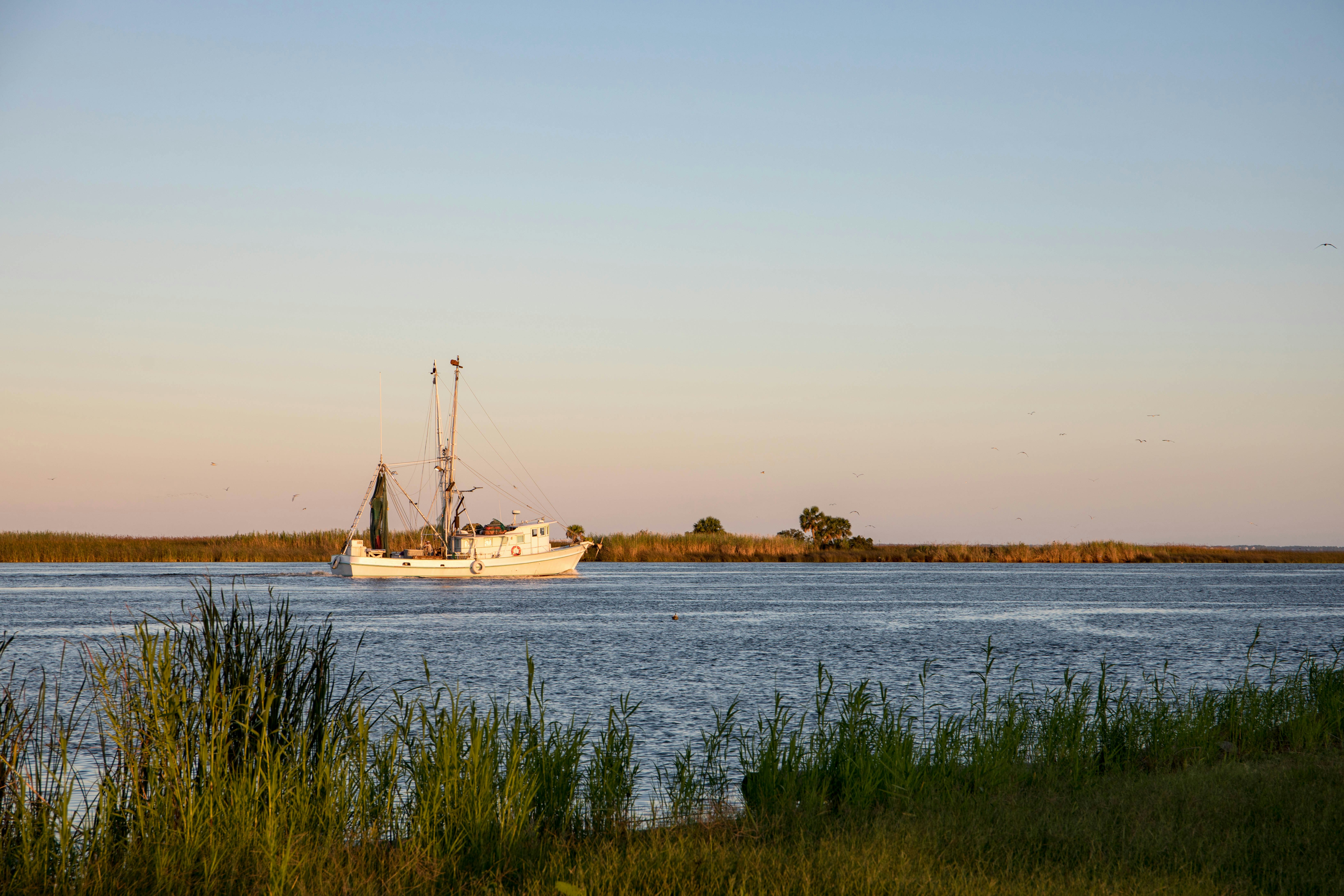 A fishing boat in dusky light on a waterway in Florida.