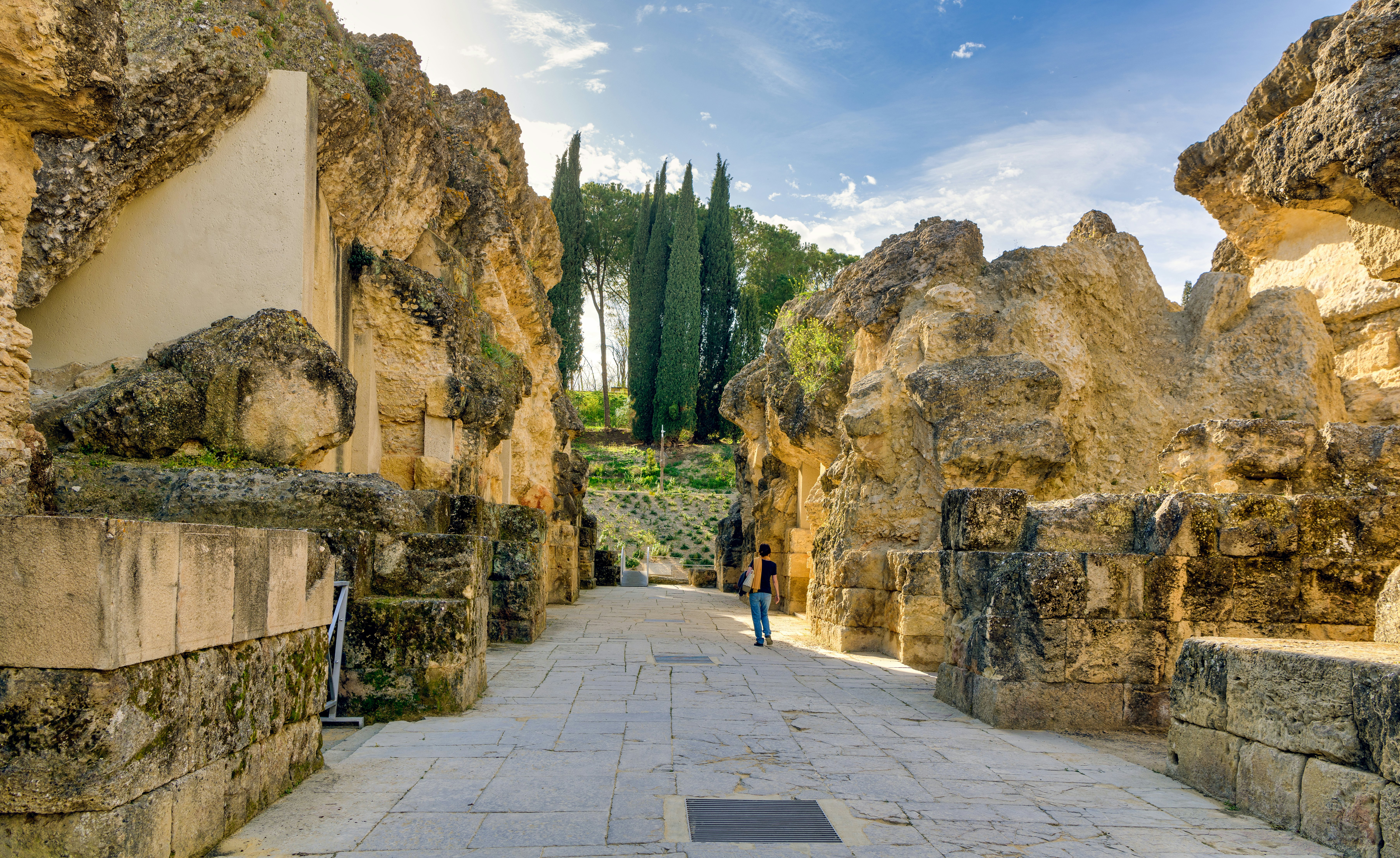 Woman walks among historic ruins in the Roman city of Italica in Santiponce, Spain.