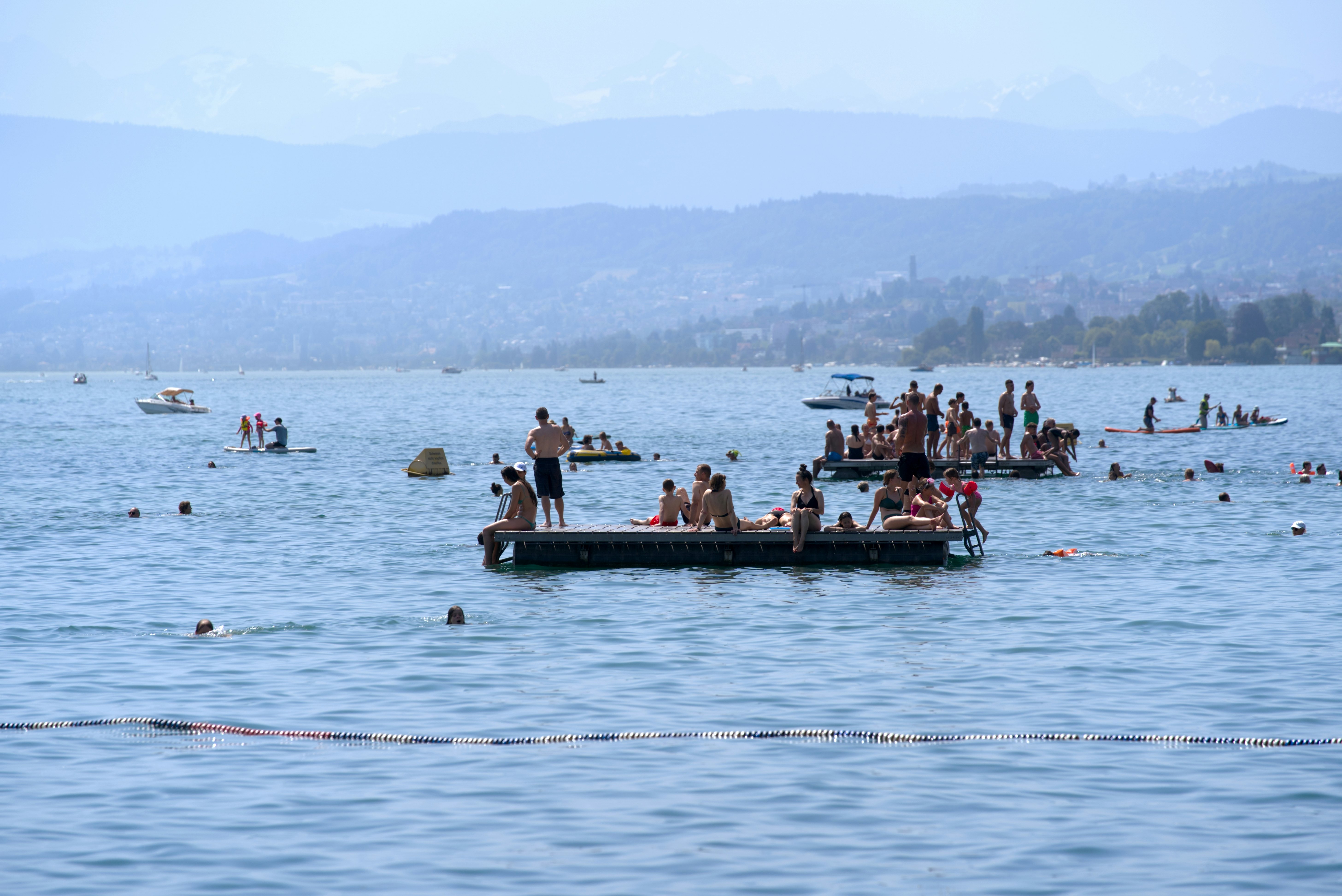 People enjoying beautiful summer das at Lake Zurich with swimming and sunbathing. Photo taken June 19th, 2022, Zurich, Switzerland.