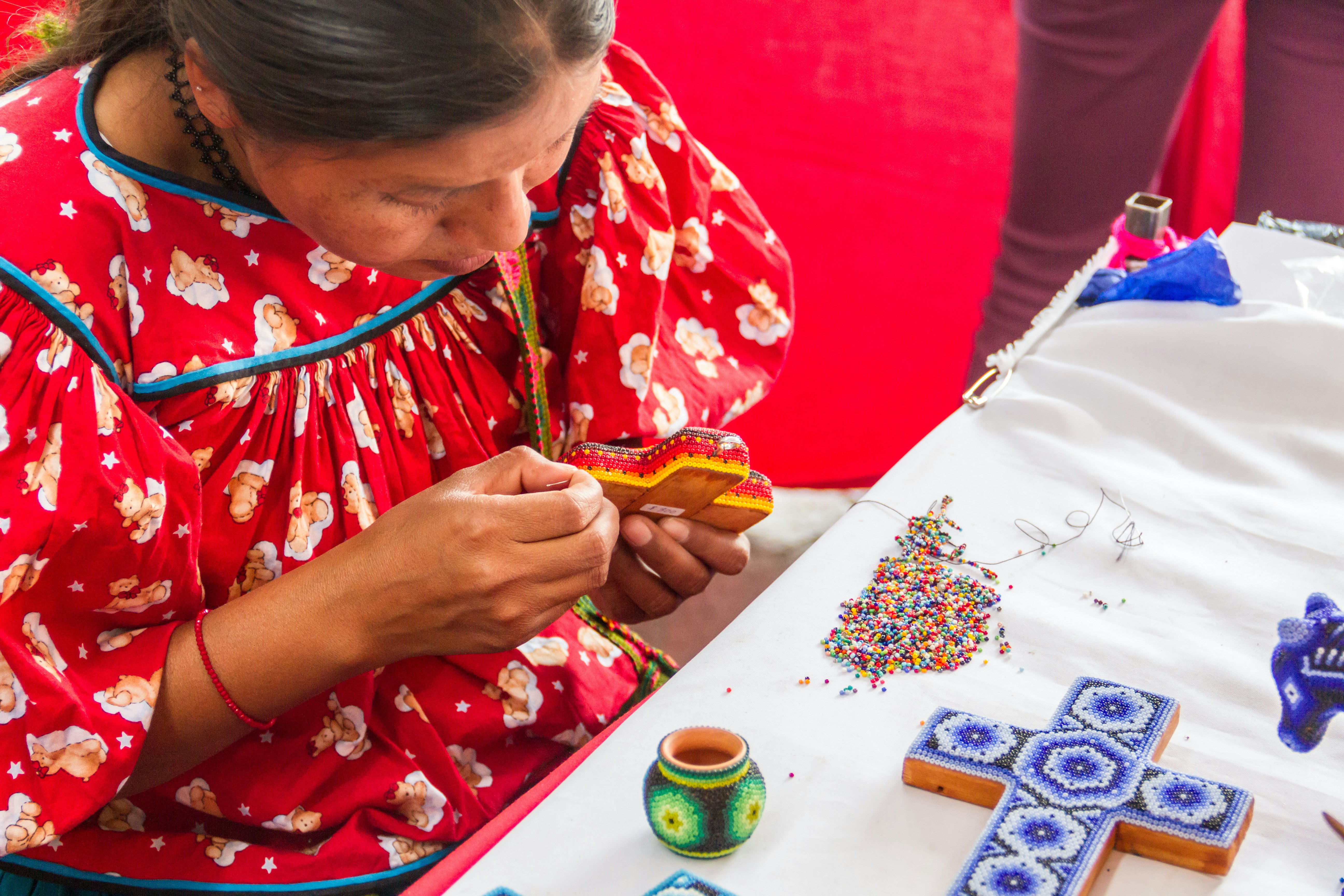 Oaxaca / Mexico. A traditional woman of the south west region of Mexico hand crafts some souvenirs.  Zapotec culture is one of the most traditional ethnicities in this part of the country