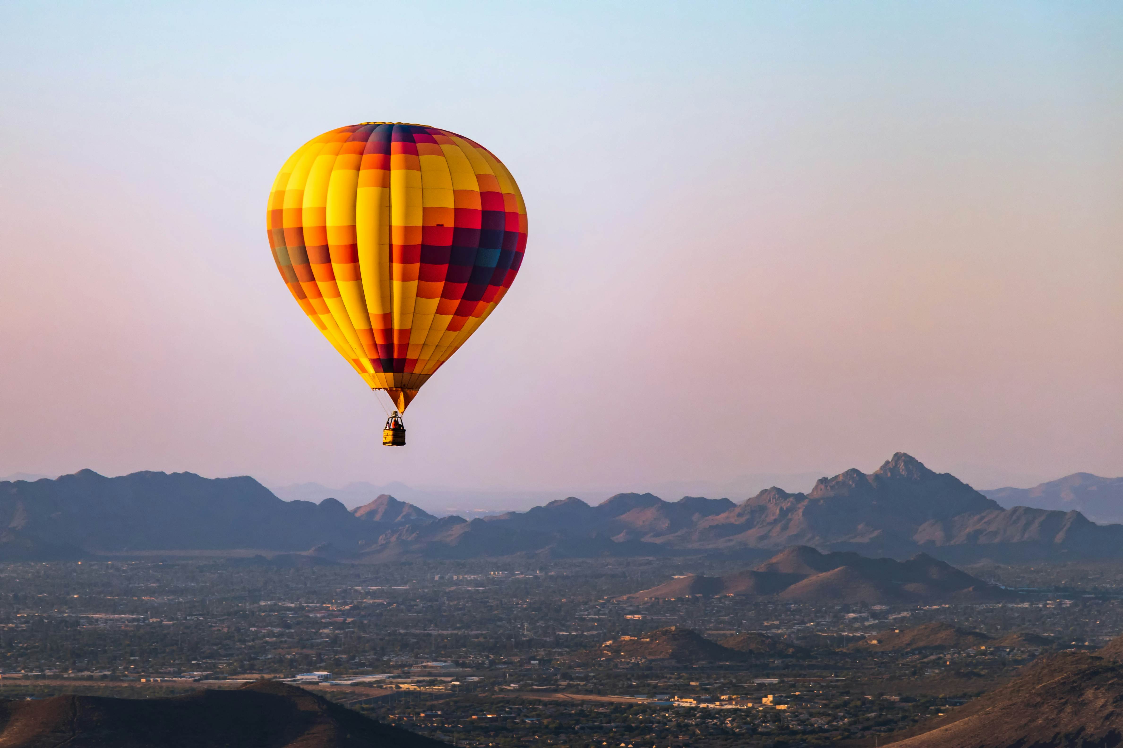A lonely hot air balloon flies over Phoenix Arizona with the Sonoran Desert in the background.; Shutterstock ID 1176204118; purchase_order:65050 - Digital Destinations and Articles; job:Online editorial; client:Guide to Phoenix refresh; other:Ann Douglas Lott
1176204118