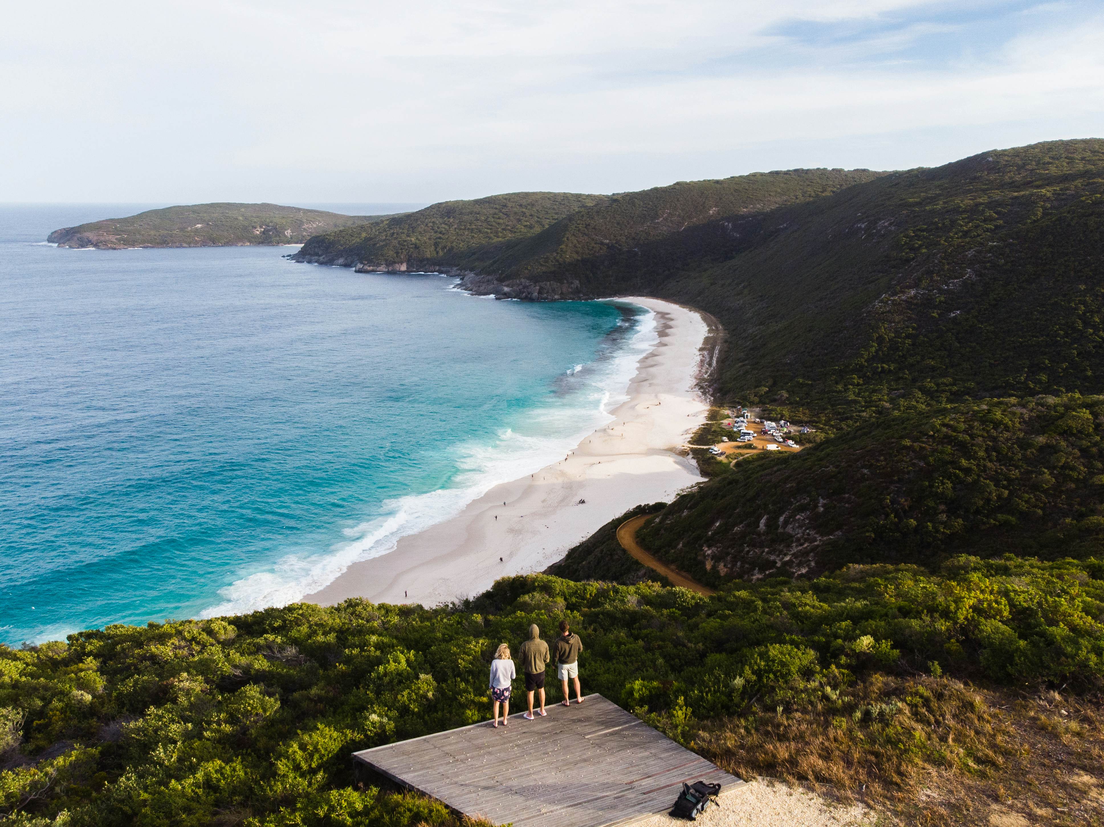 Group of travellers watching the sunset over a beach in Albany, Australia. Beautiful remote beach down below the three travellers. Shot aerially from a drone. , License Type: media, Download Time: 2026-01-12T17:12:22.000Z, User: katelyn.perry_lonelyplanet, Editorial: false, purchase_order: 65050 - Digital Destinations and Articles, job: wip, client: wip, other: Katelyn Perry