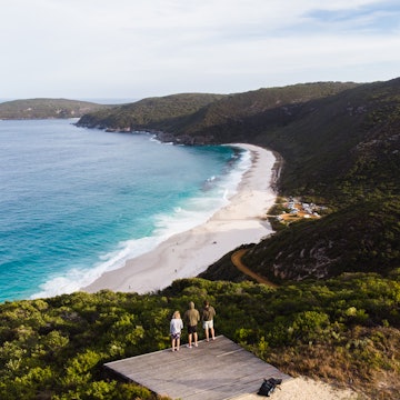 Group of travellers watching the sunset over a beach in Albany, Australia. Beautiful remote beach down below the three travellers. Shot aerially from a drone. , License Type: media, Download Time: 2026-01-12T17:12:22.000Z, User: katelyn.perry_lonelyplanet, Editorial: false, purchase_order: 65050 - Digital Destinations and Articles, job: wip, client: wip, other: Katelyn Perry