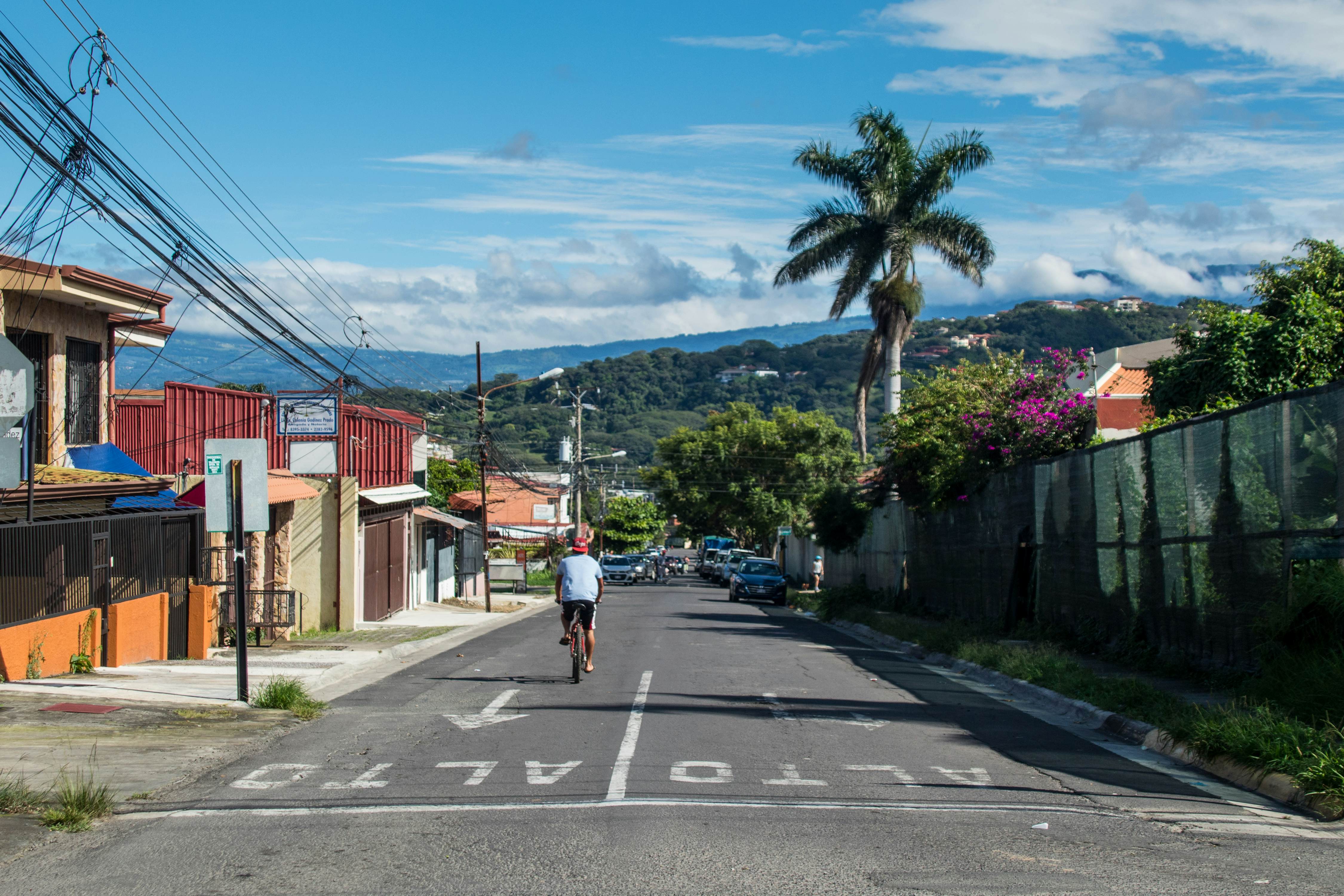 Santa Ana, San Jose / Costa Rica - 07.22.2019: A biker riding on the beautiful  Calle Central (Central Street) in Santa Ana
1605094480
architecture, background, beautiful, biker, blue, building, buildings, cables, central street, central valley, city, clean, clouds, colorful, destination, editorial, electricity, empty, fence, greenery, home, iconic, illustrative, intersection, landmark, landscape, life, mountains, pali, palm tree, people, road, santa ana, scenic, sky, street, summer, sunny, tourism, tourist, town, transportation, travel, urban, vacation, vegetation, view, village, wallpaper, wires