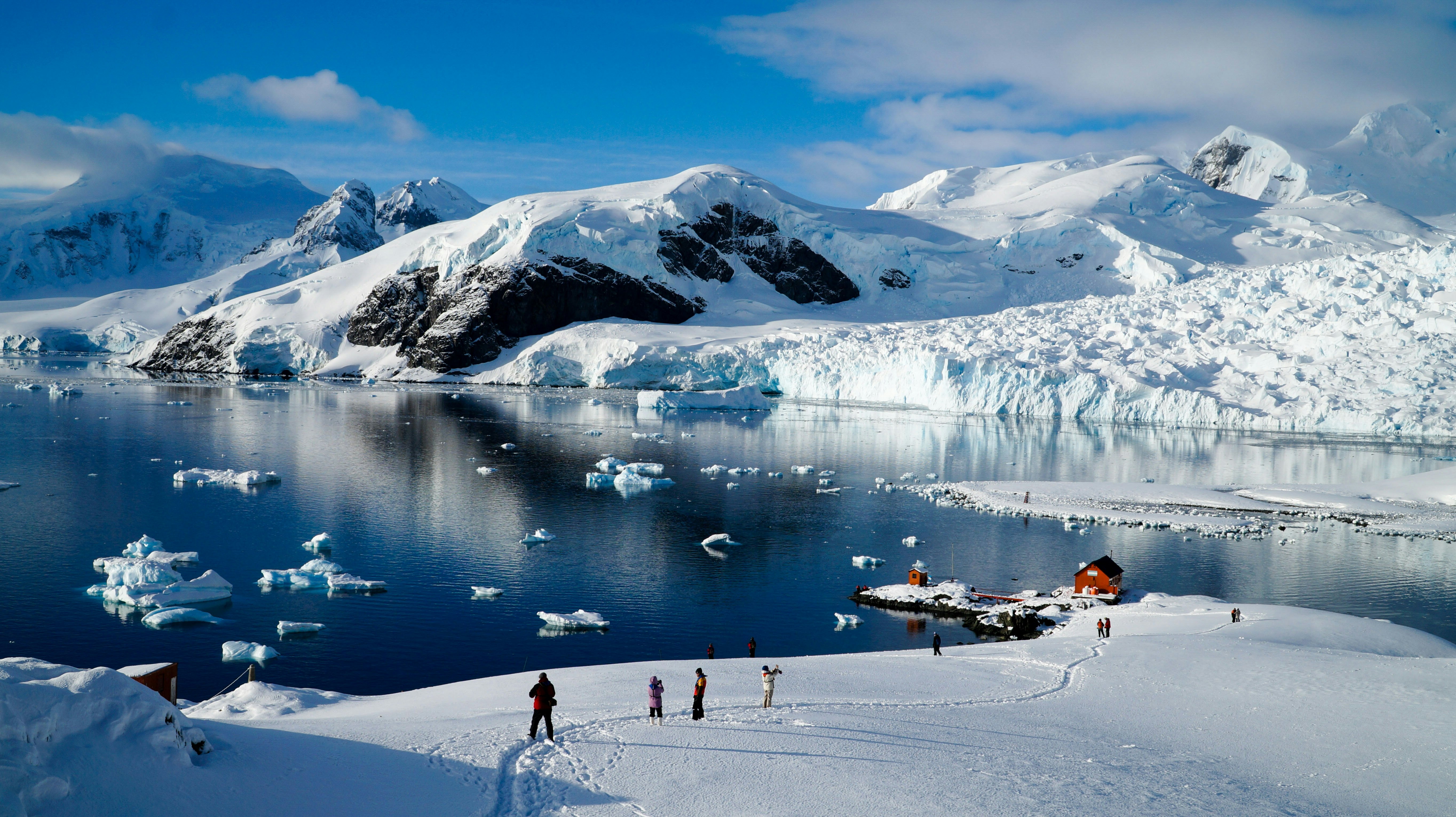 People standing in the snow near the water in Paradise Bay, Antarctica