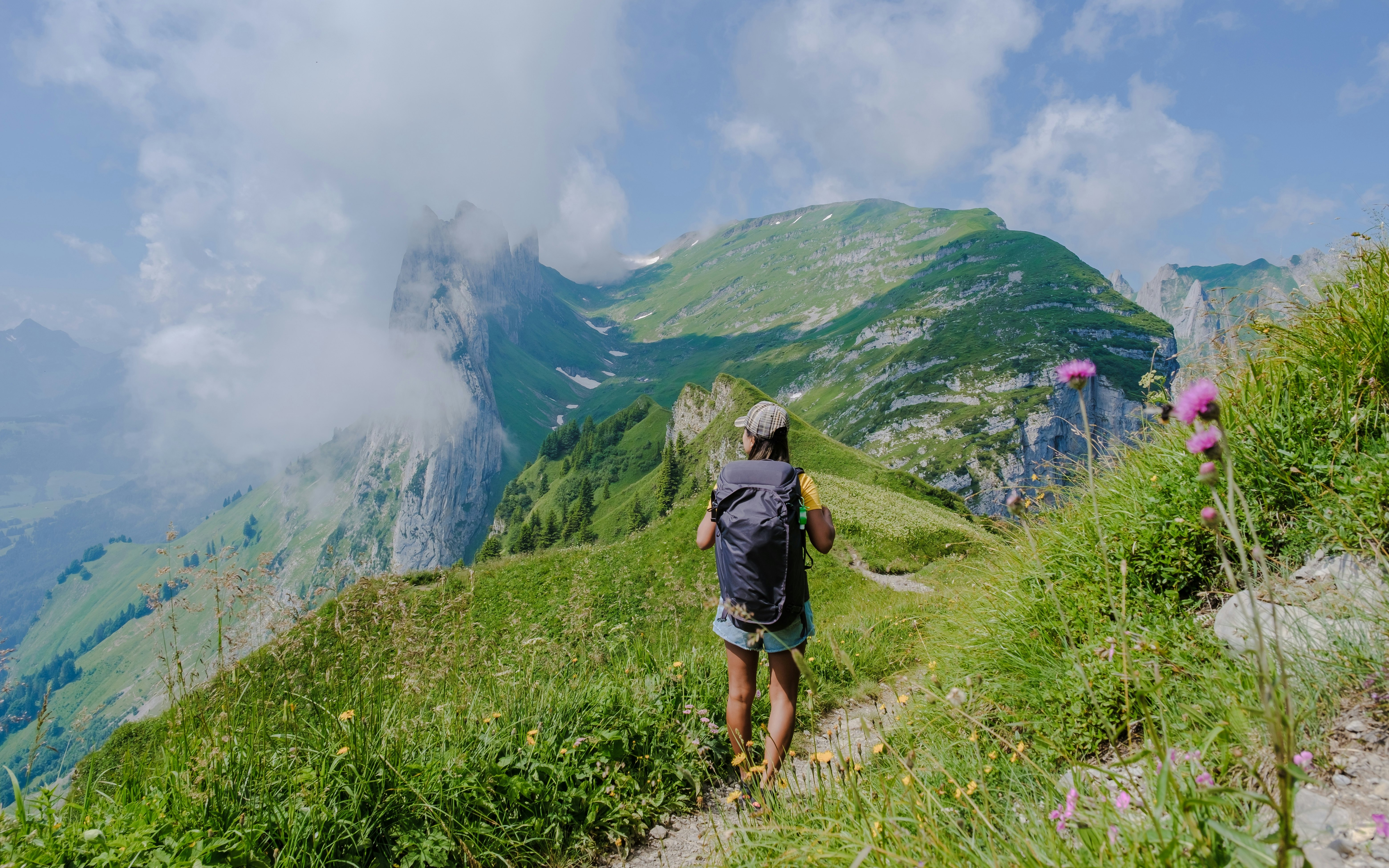 Woman hiking in the Swiss Alps mountains during summer vacation with a backpack and hiking boots. woman walking on the Saxer Lucke path a popular hiking trail in Switzerland