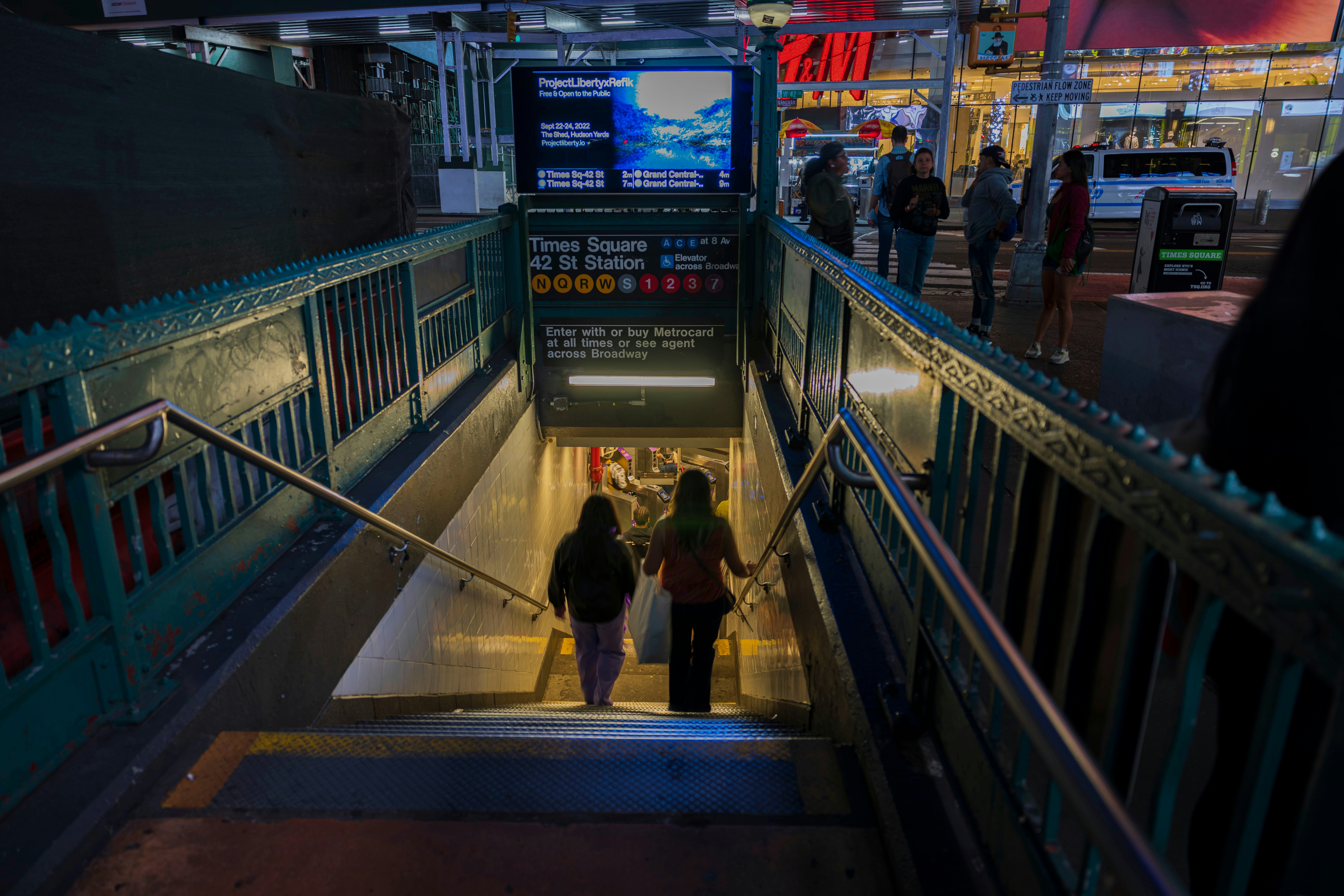 Night view of people entering subway at Times Square Station.