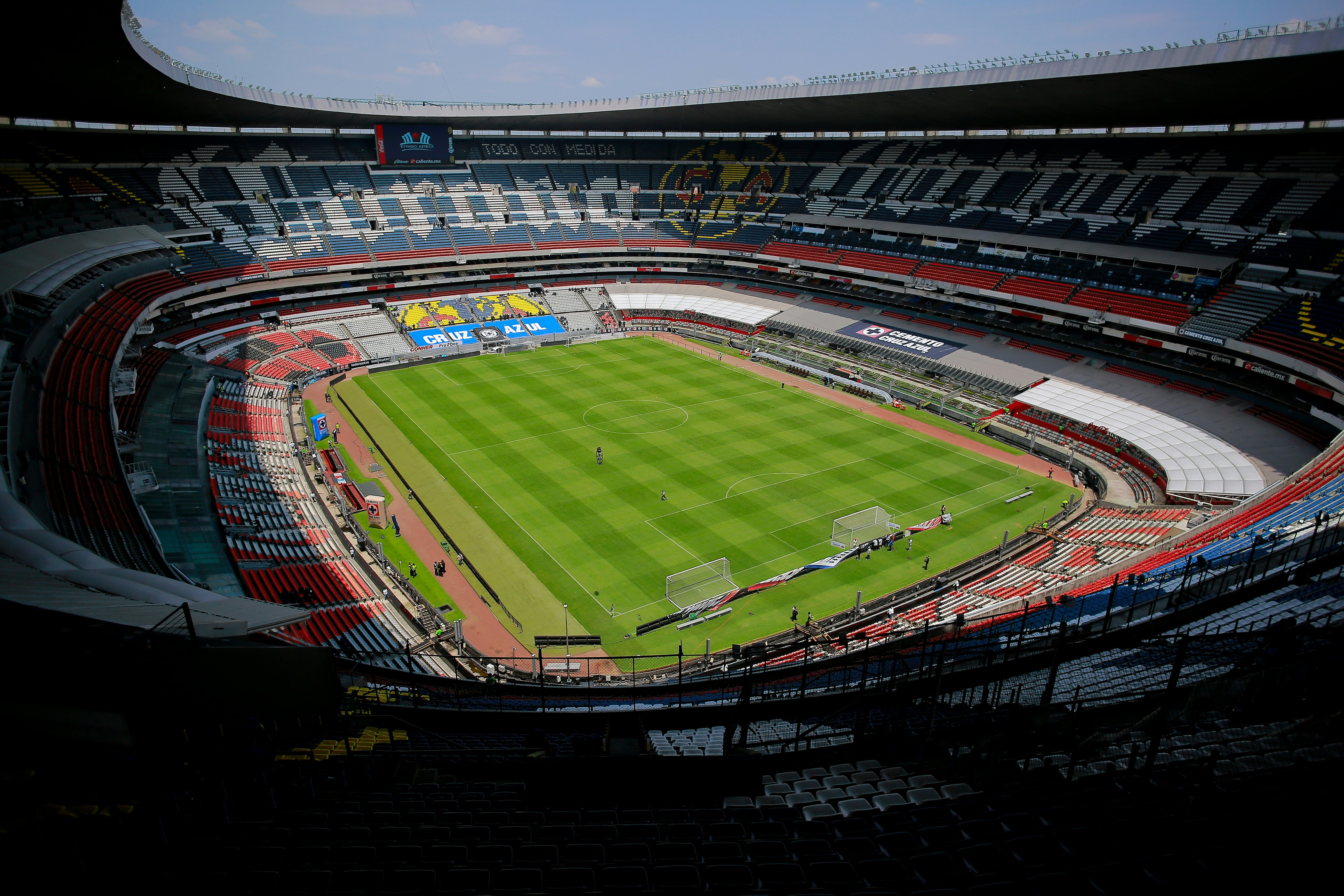 A huge, empty area is pictured, with a green soccer pitch at the center of tiers of thousands of seats.