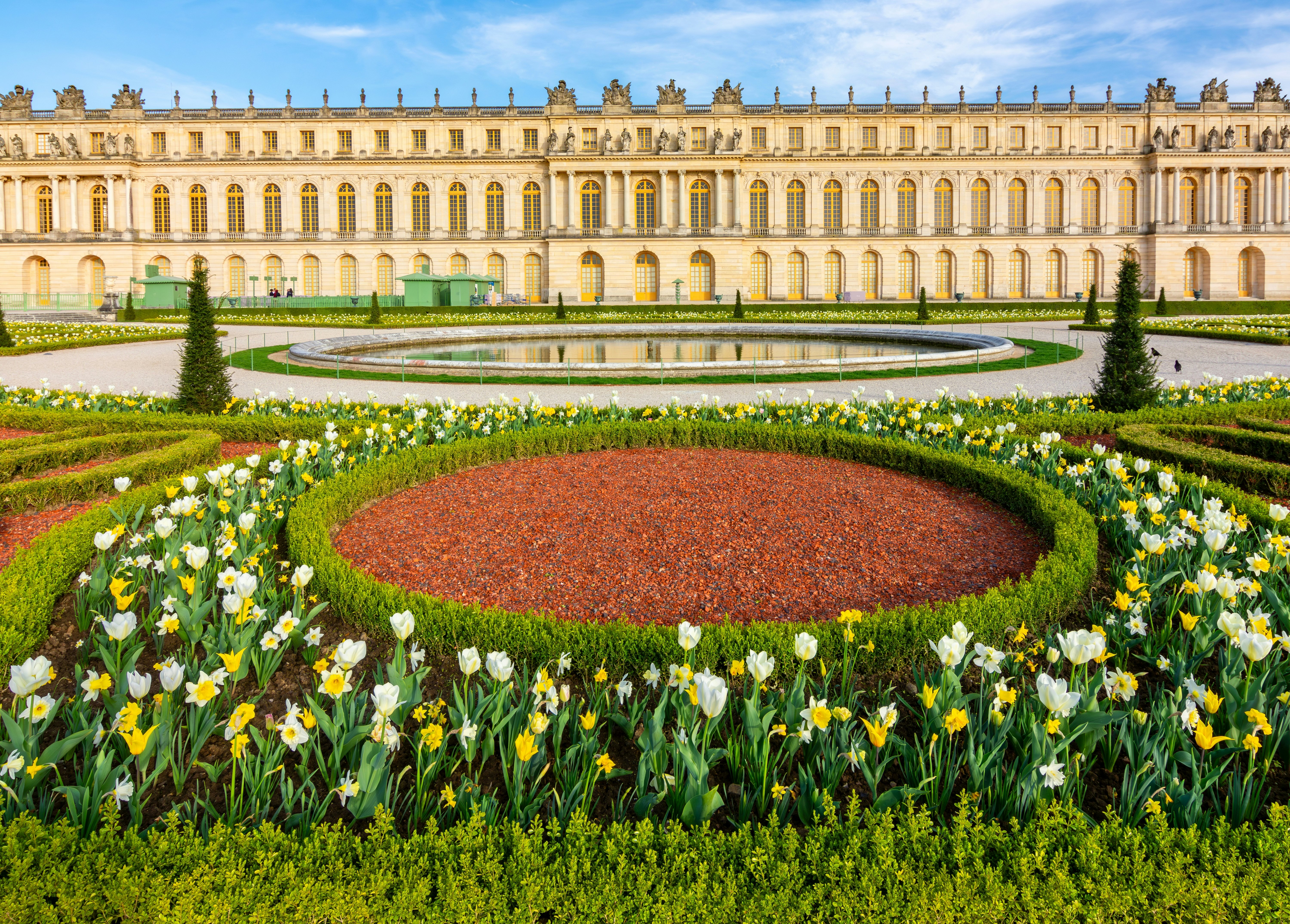Spring flowers in bloom in a garden in front of an opulent palace.