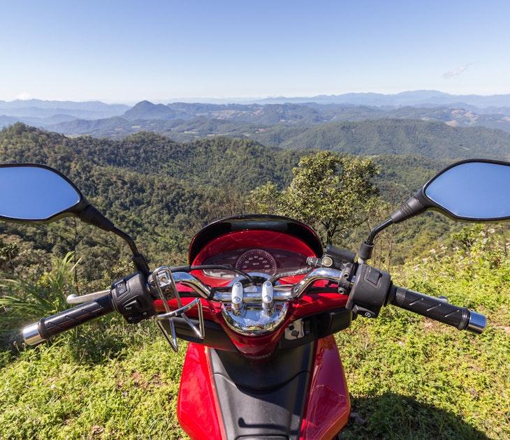 Red motorbike on the edge of a hill and green mountains in sunny day in Thailand; Shutterstock ID 538299268; purchase_order:65050 - Digital Destinations and Articles; job:Digital editorial ; client:How riding a motorbike in Southeast Asia set me free; other:Acacia Gabriel
538299268
