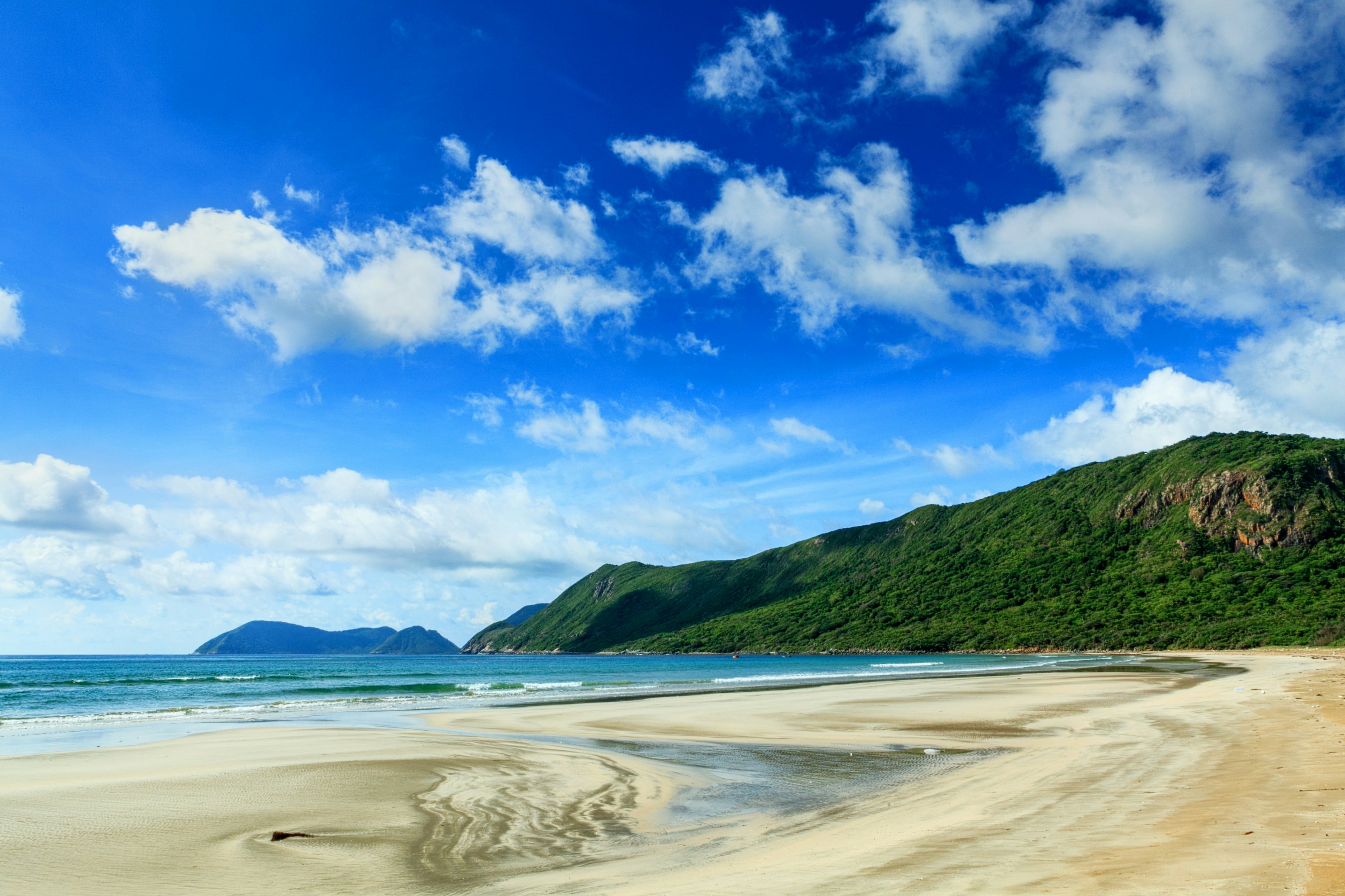 An empty beach under blue skies on Con Son island, Vietnam.