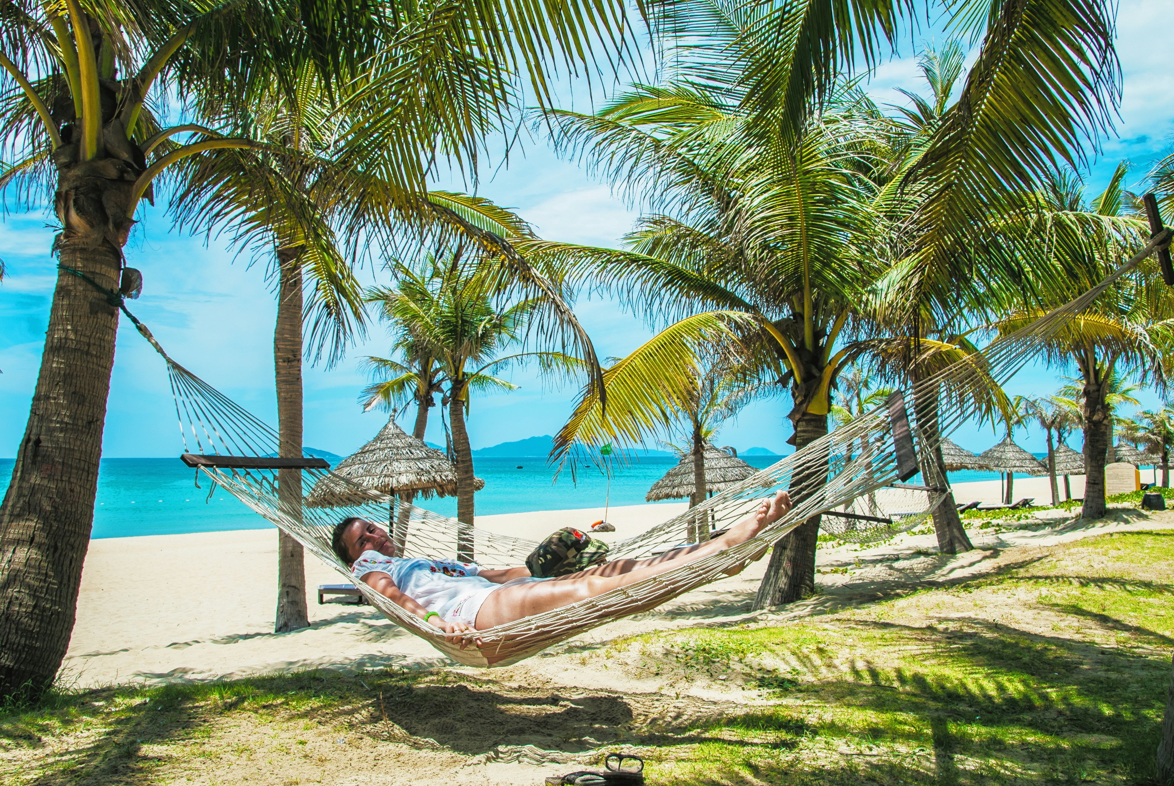 The An Bang beach with a woman resting on a hammock.