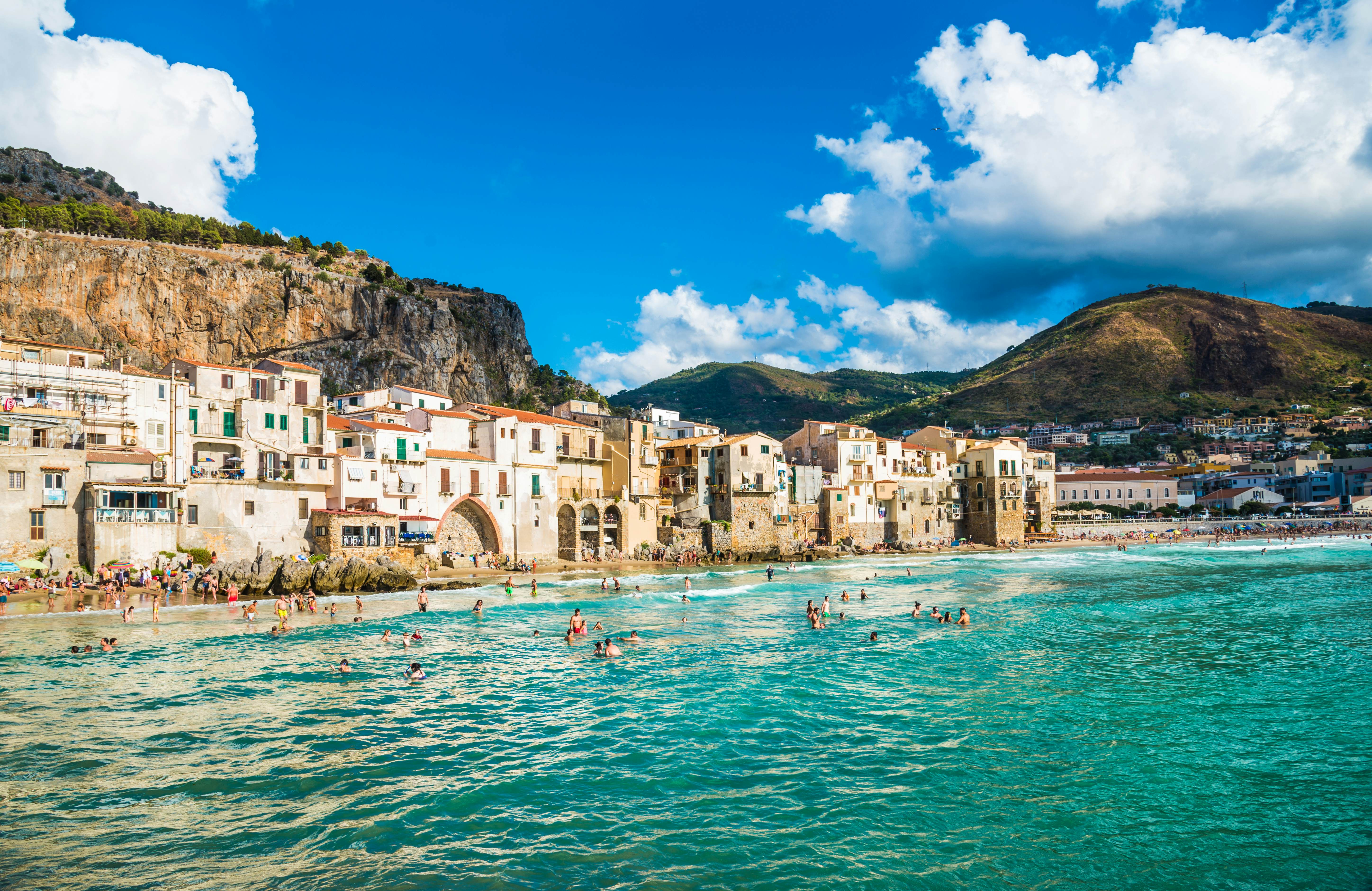 CEFALU, SICILY - AUGUST.12. 2017: People on beautiful beach at the bay in Cefalu, Sicily.Cefalu is very popular touristic old town in Sicily., License Type: media, Download Time: 2025-02-18T21:18:57.000Z, User: katelyn.perry_lonelyplanet, Editorial: true, purchase_order: 65050 - Digital Destinations and Articles, job: WiP, client: WiP, other: Katelyn Perry