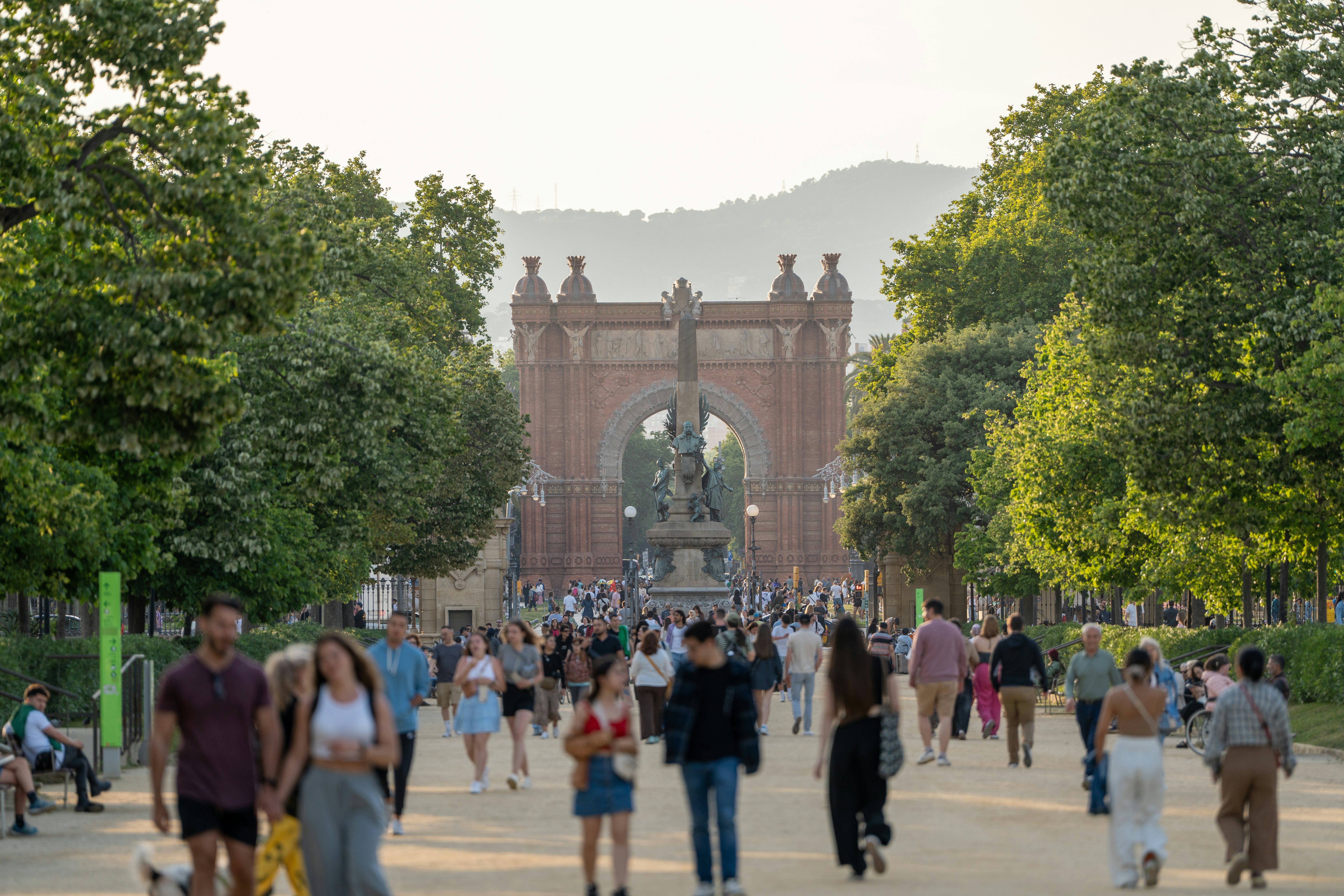 People promenade in Parc de la Ciutadella in the late afternoon, Barcelona, Spain.