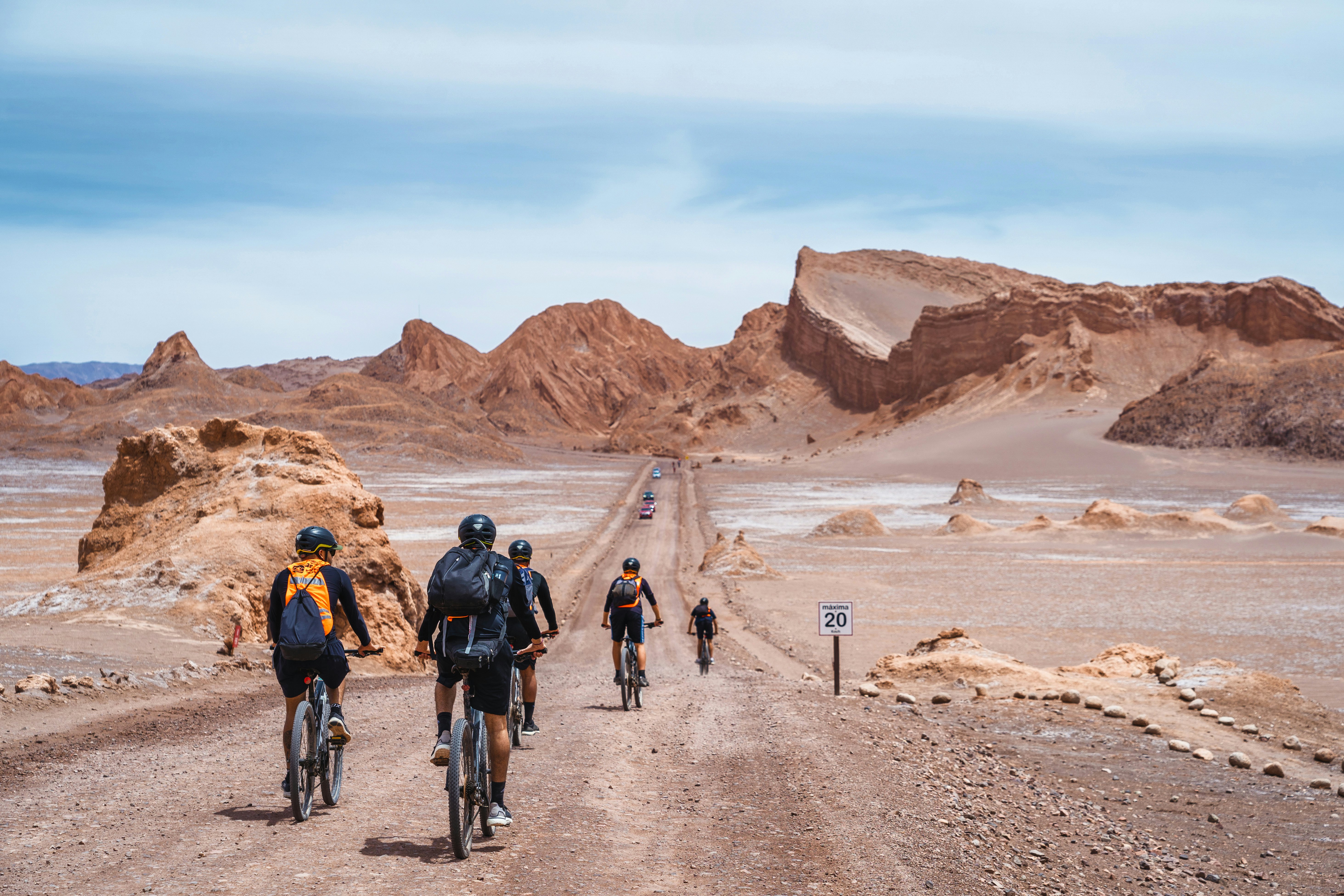 Cyclists explore the Valle de la Luna near San Pedro de Atacama, Chile, with rugged desert formations beyond.
