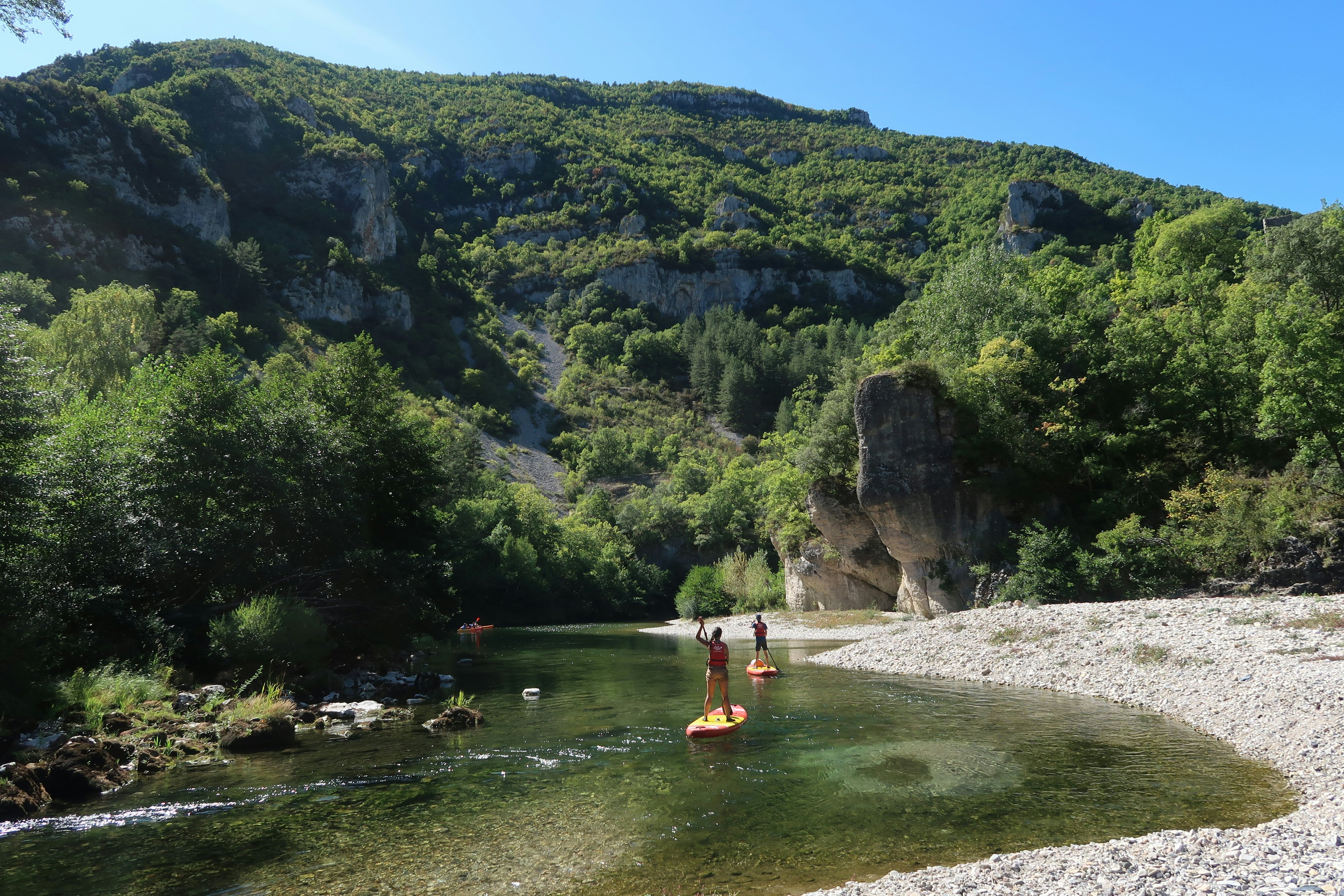 Tourists paddle boarding on the river running through Gorges du Tarn in France