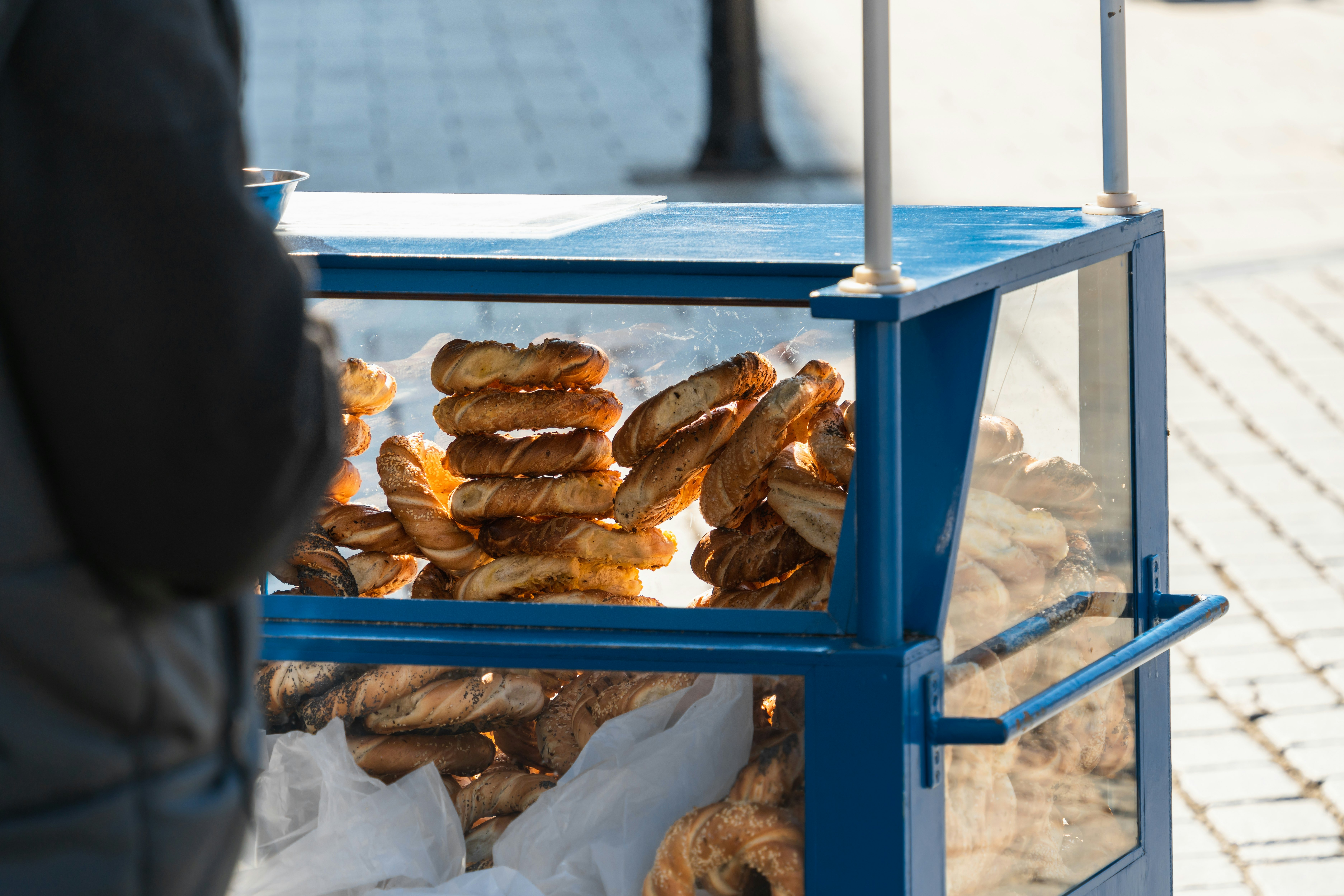 Street stall with Polish bagels in Krakow, round traditional pretzels with poppy seeds, cumin and salt on a sunny day on the city street