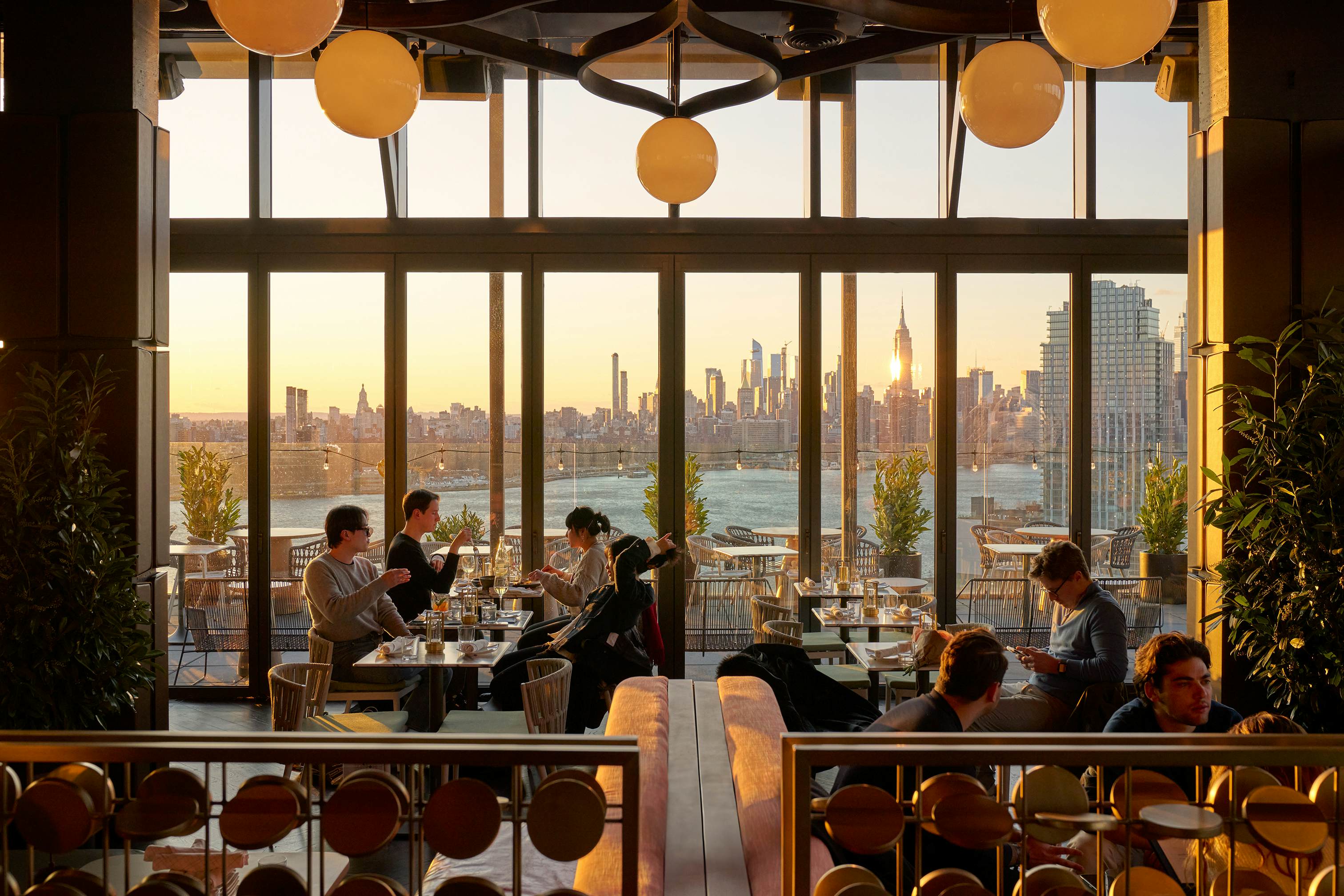 People dining in a rooftop bar with a city skyline view