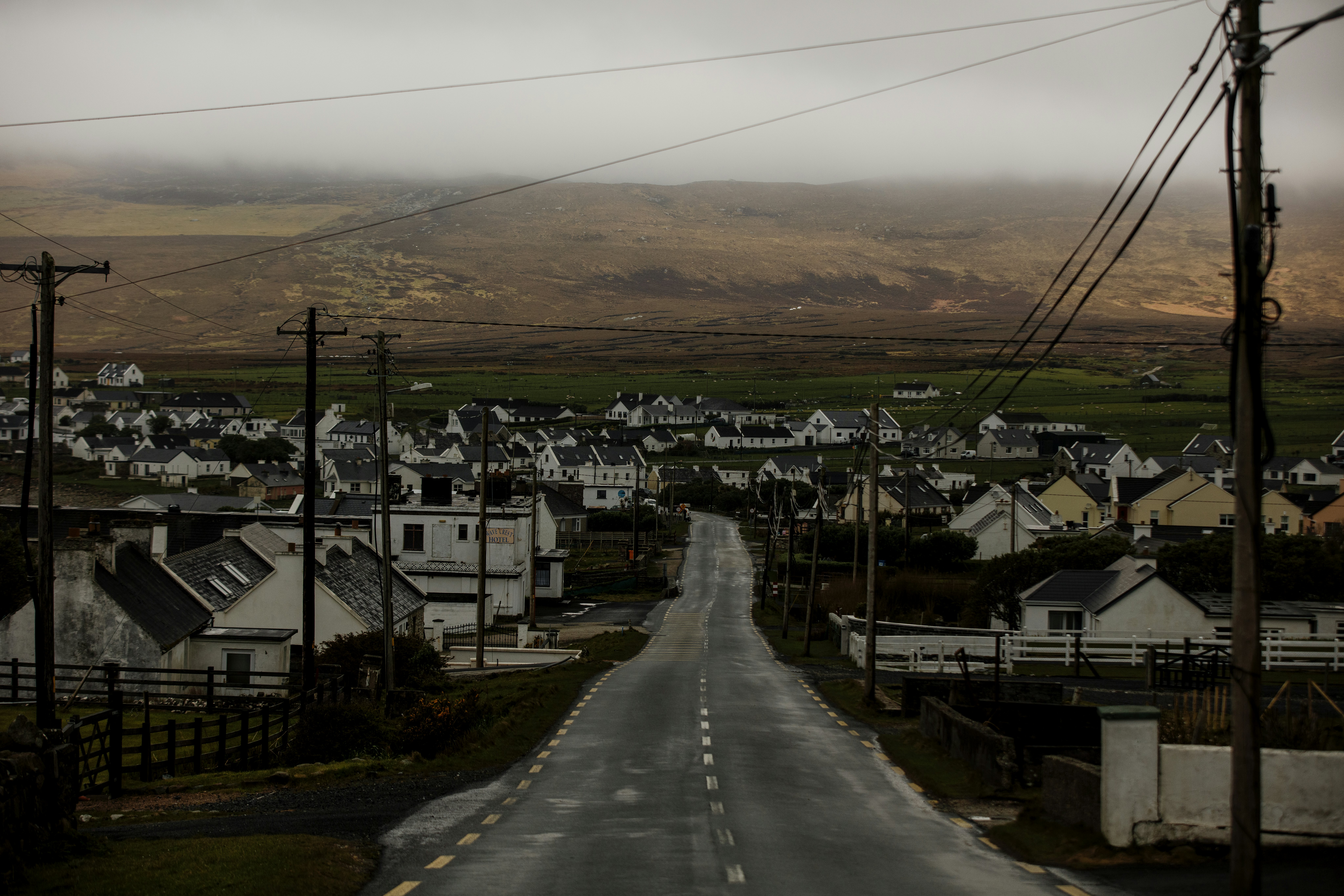 A paved road cutting through a cluster of modest homes