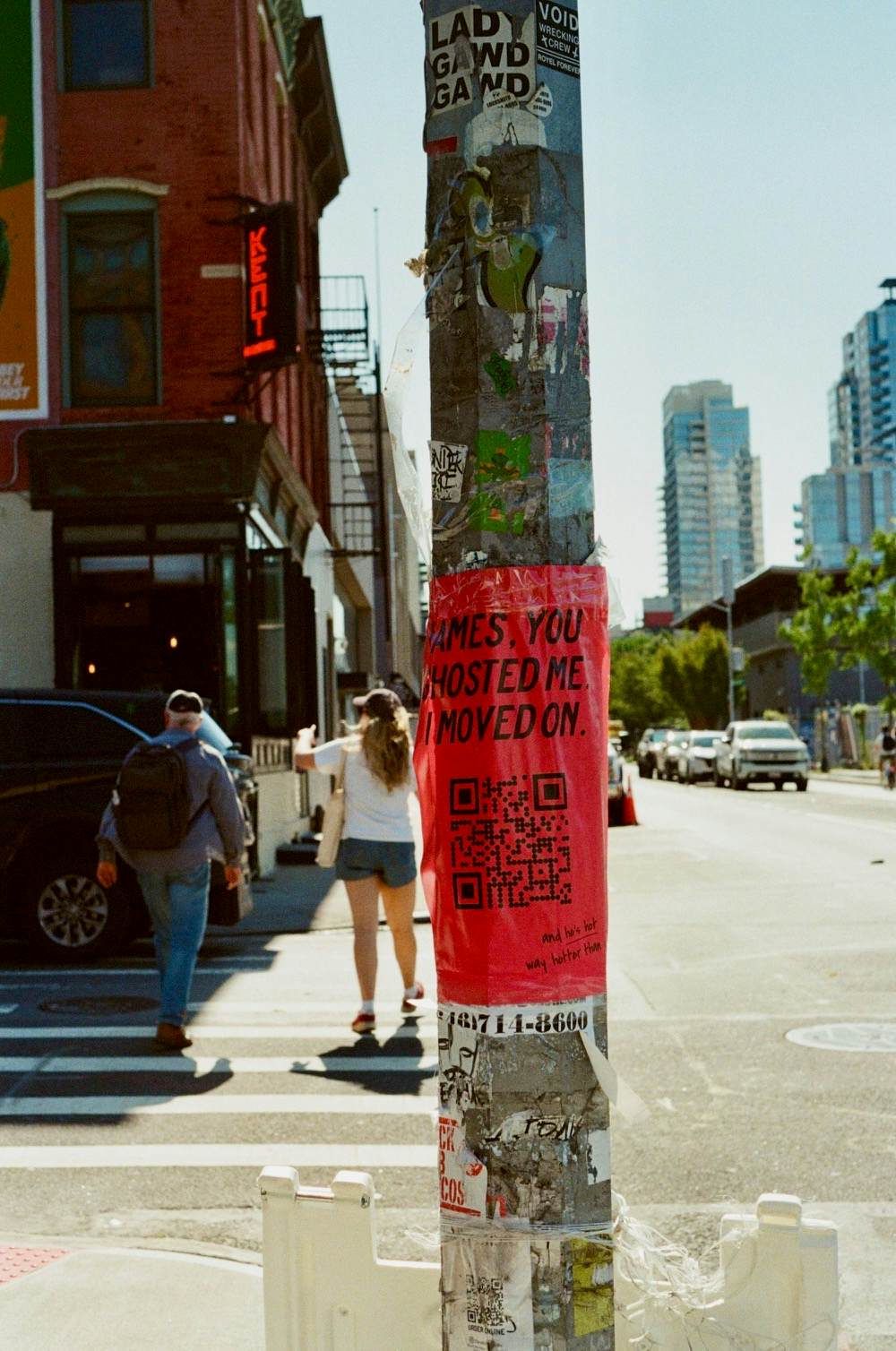 A red sign with a QR code wrapped around a pole 