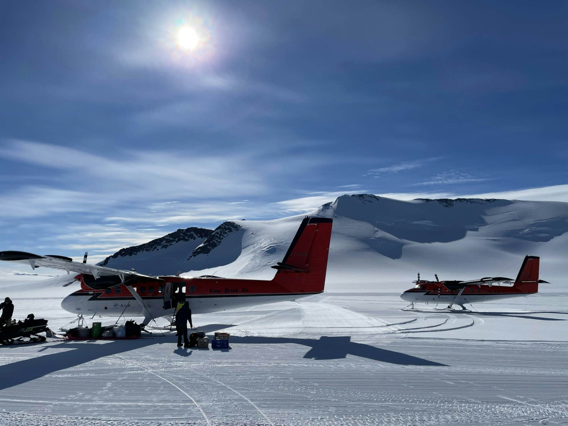 Two small planes on a snow-covered surface.