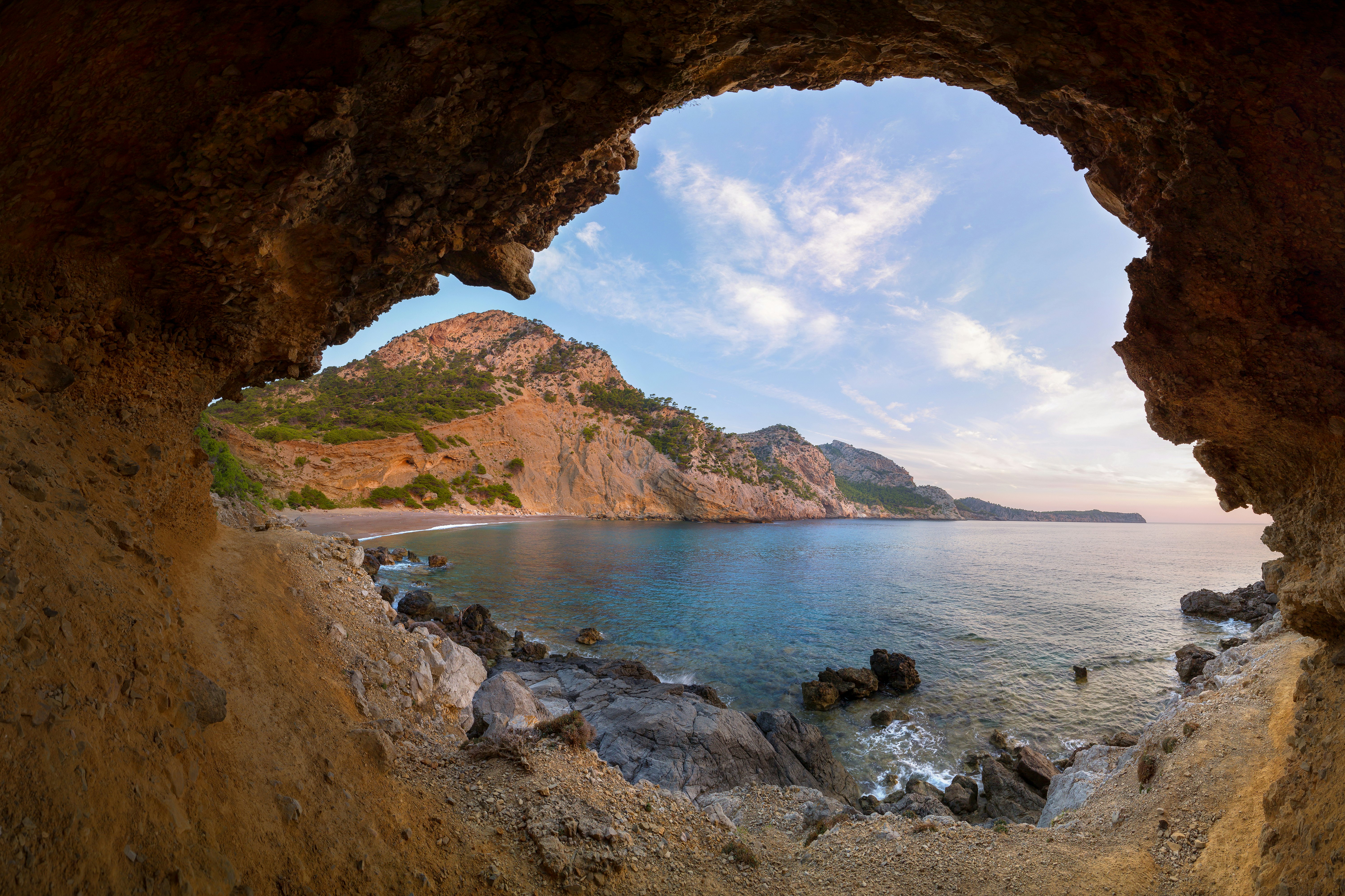 A secluded beach viewed from within a cave.