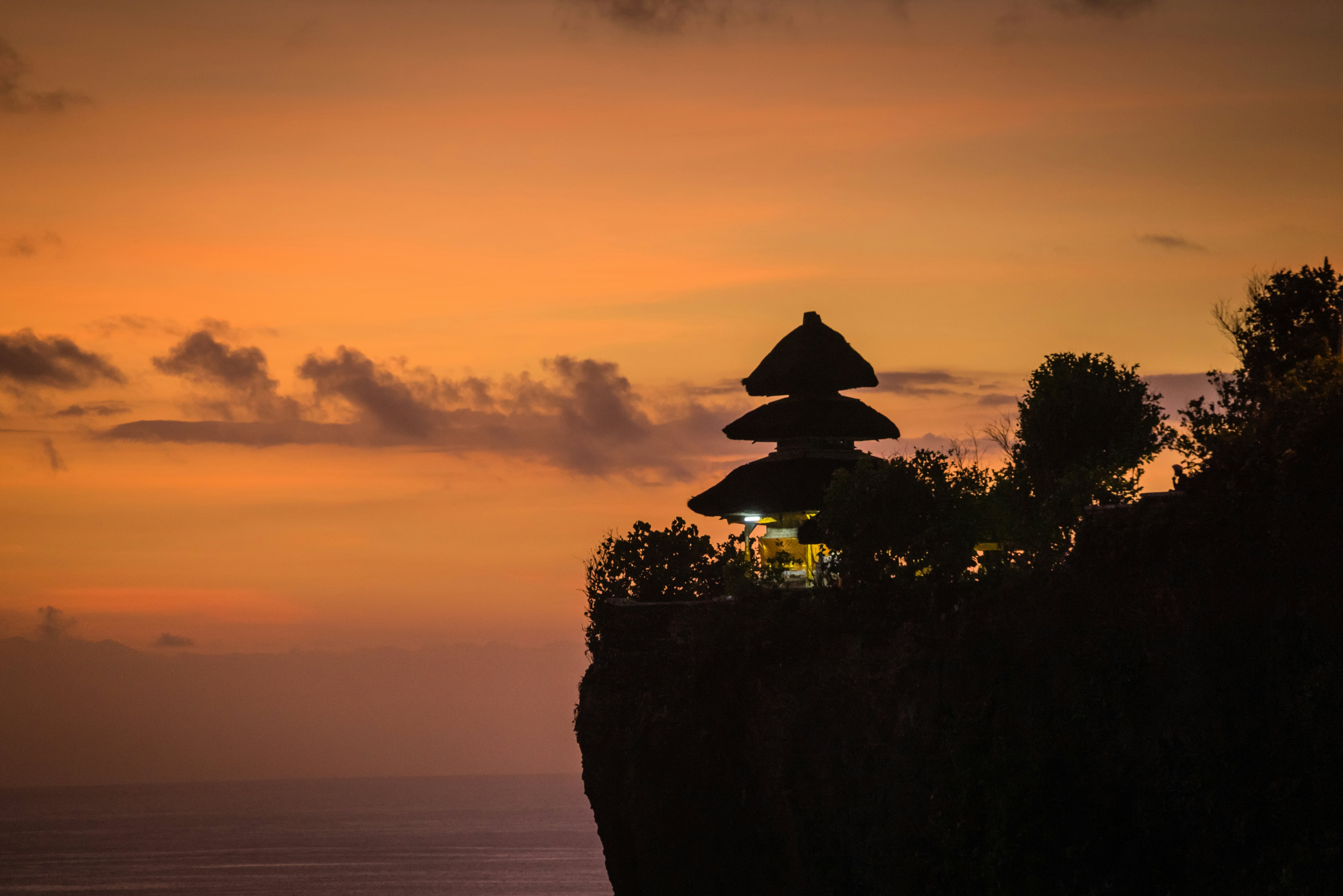 Sunset at a three-tiered temple on a cliff by the sea.