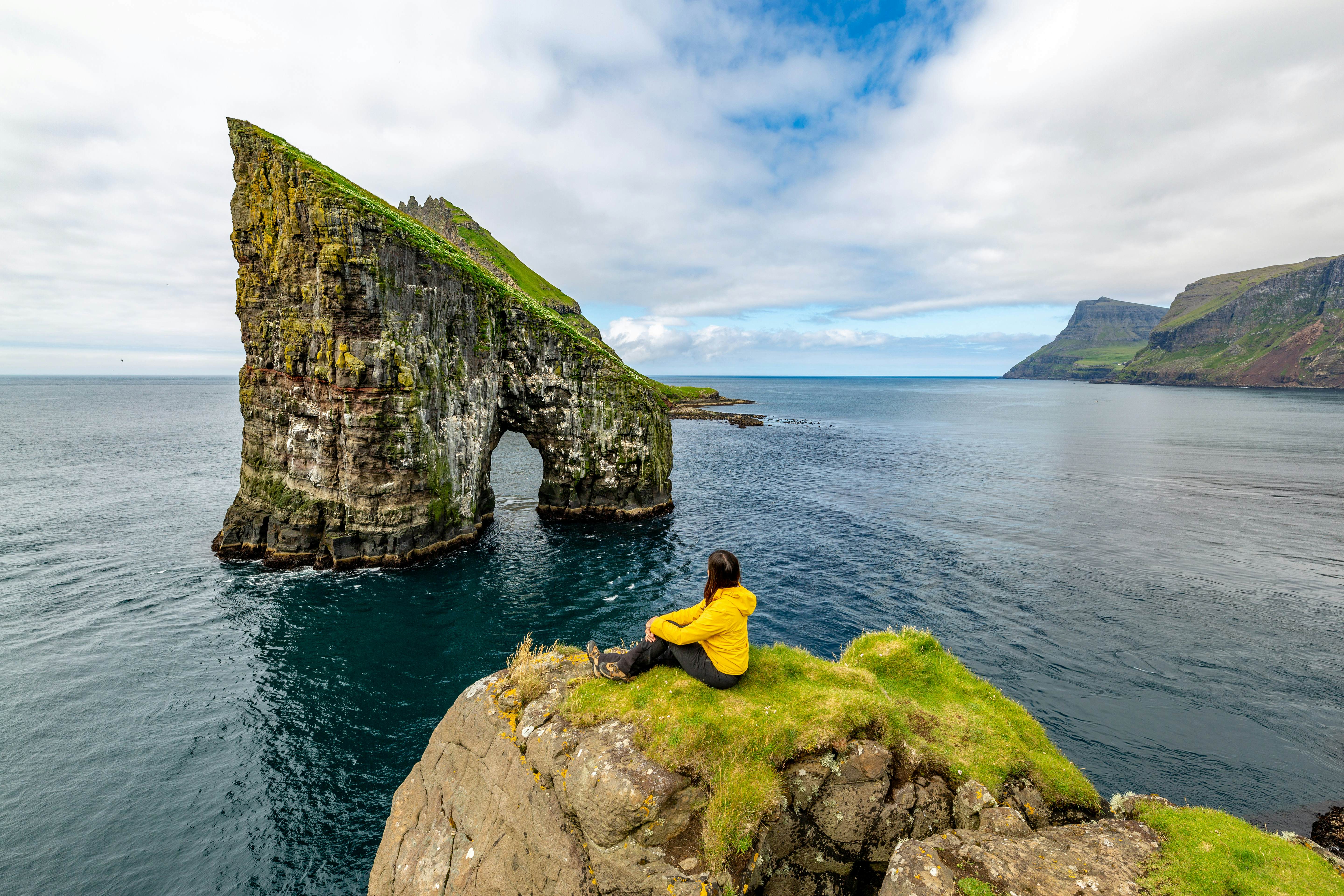 hiker admiring Drangarnir rocks at Faroe Islands, wild landscape, License Type: media, Download Time: 2025-02-04T23:10:12.000Z, User: claramonitto, Editorial: false, purchase_order: 56530 - Guidebooks, job: Global Publishing-WIP, client: Scandinavia 15, other: Clara Monitto